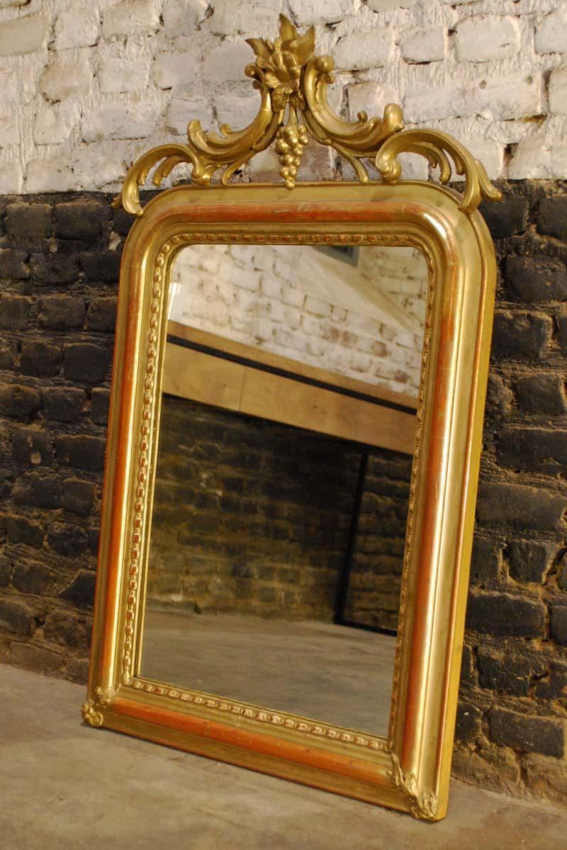 Louis Philippe mirror with an ornate crest.
Frame and crest are both gold leaf gilded and gold laquered.
Original gold, original glass with minor wear.
Originates: South of France, dating, circa 1850.