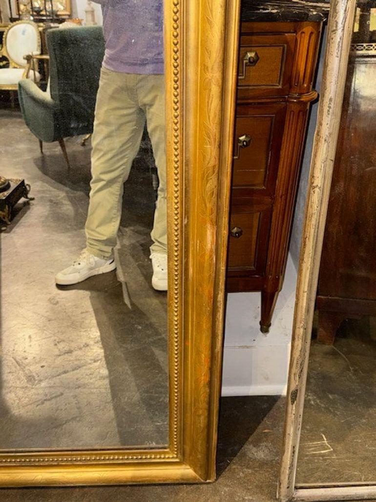 Ce miroir Louis Philippe du XIXe siècle présente une luxueuse finition dorée avec un magnifique motif floral sur le cadre, ajoutant une touche d'élégance et de sophistication à tout espace. Le style Louis Philippe classique du miroir dégage un