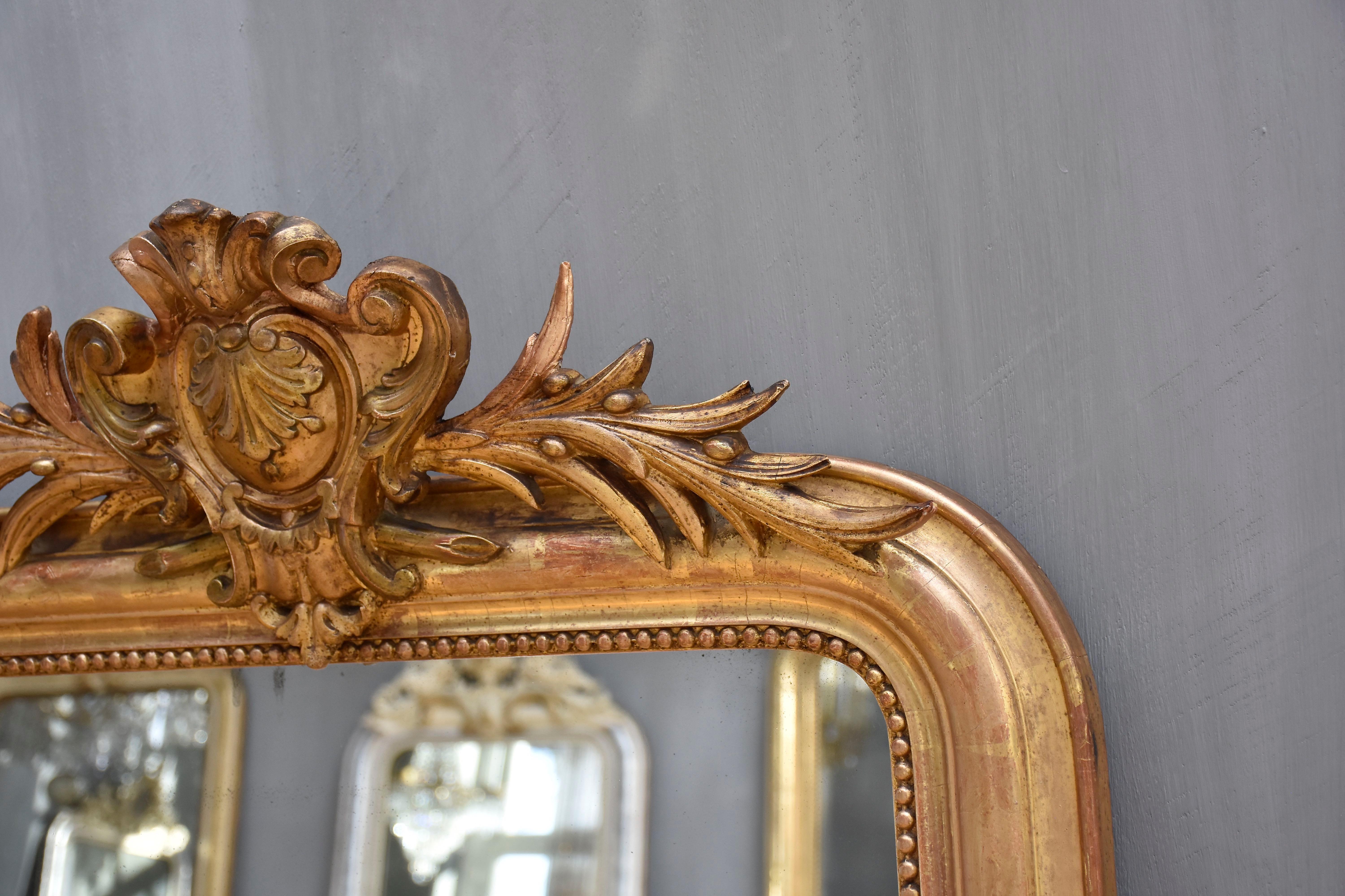 Giltwood 19th century gold leaf gilded French mirror Louis Philippe with a crest For Sale