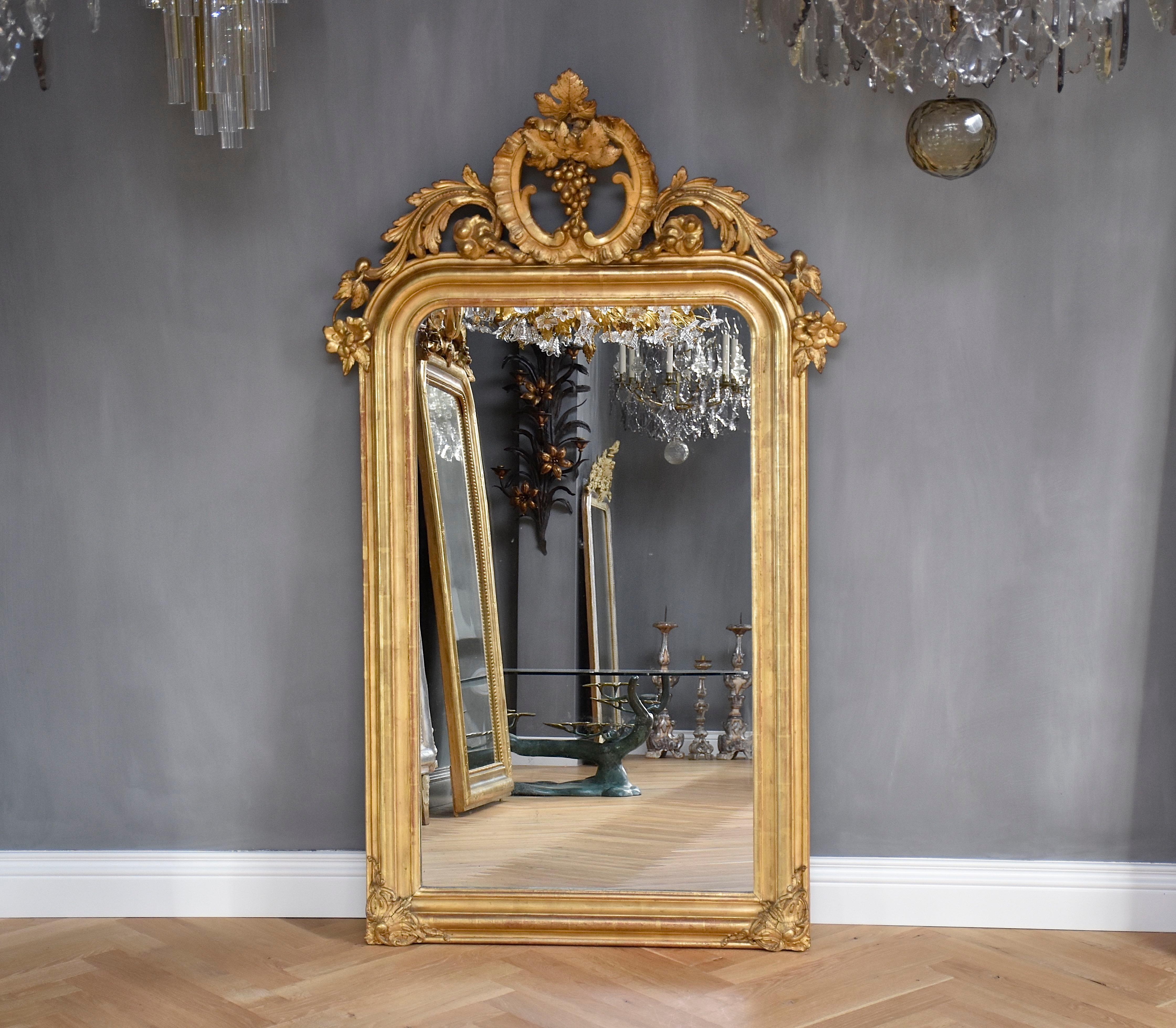 Magnifique miroir français doré du 19e siècle, avec son verre antique d'origine légèrement rongé par la rouille et une belle couronne.
La couronne est ornée de fleurs, de feuilles, de C.I.C. et de grappes de raisin.
Les coins sont ornés de jolies
