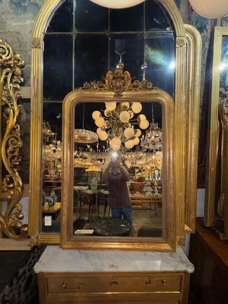 Specchio Louis Philippe in oro del XIX secolo con stemma. Il design elegante aggiunge un tocco di raffinatezza a qualsiasi ambiente. Questo specchio ha un fascino vintage grazie alla sua finitura dorata e agli intricati dettagli ispirati allo stile