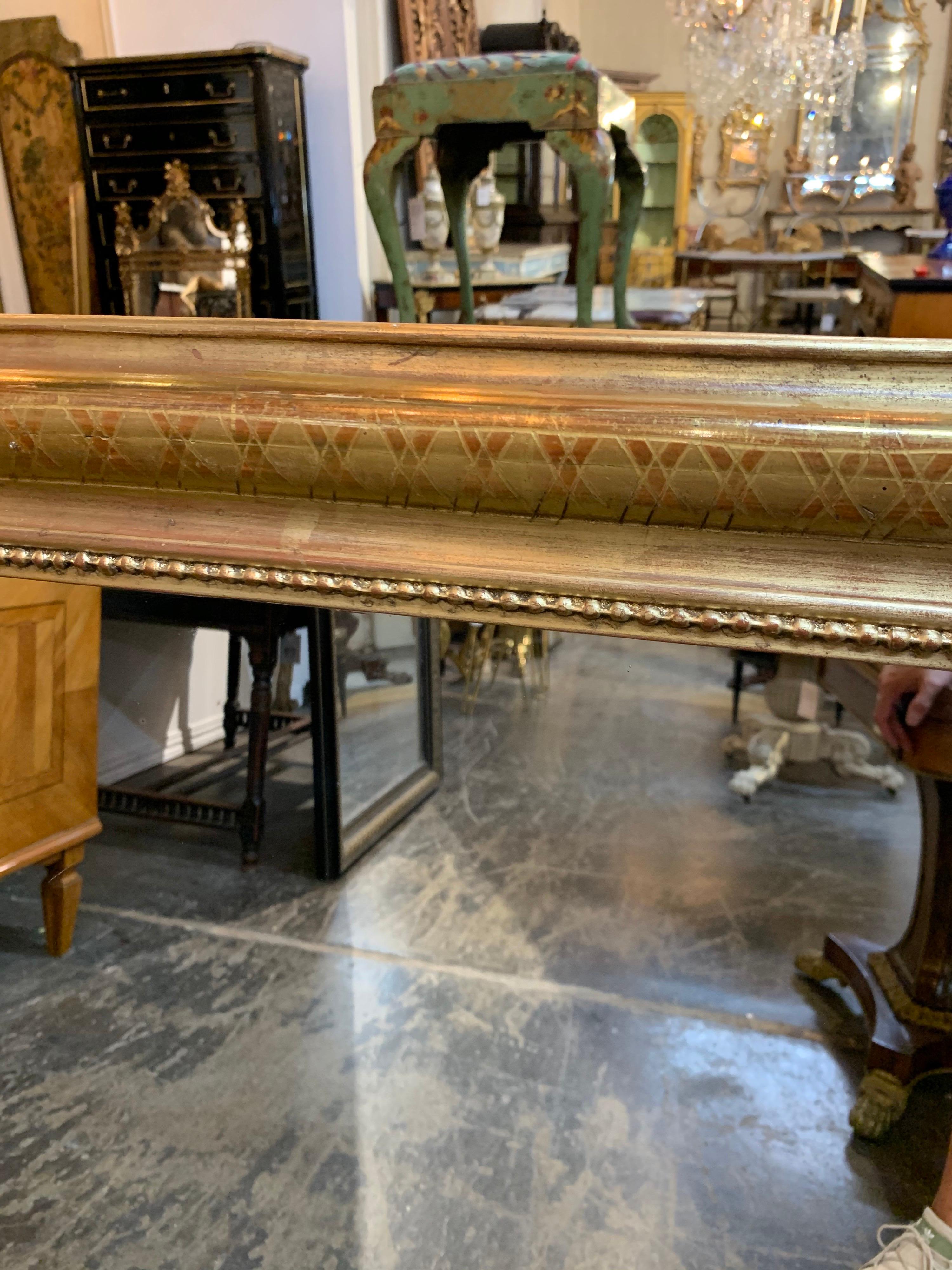 Lovely 19th century gold Louis Philippe mirror with X-pattern. This mirror has red undertones and a beaded inner border. A beautiful decorative mirror!