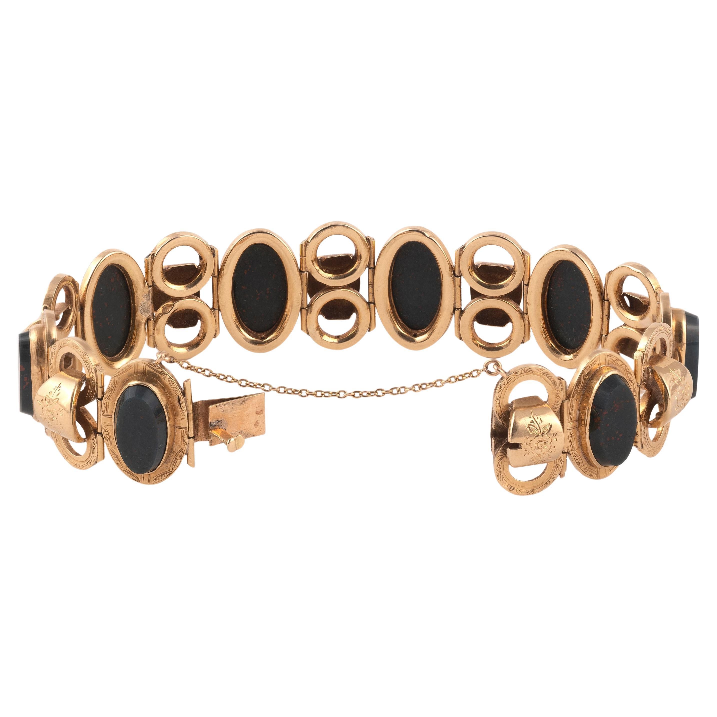 Articulated bracelet in 18k gold, composed of oval slabs of blood jasper alternating with knotted links, the whole chased with foliate friezes, ratchet clasp with safety chain.
Italian work, mid-19th century
Gross weight : 26.20 g. 
Length : 18.5