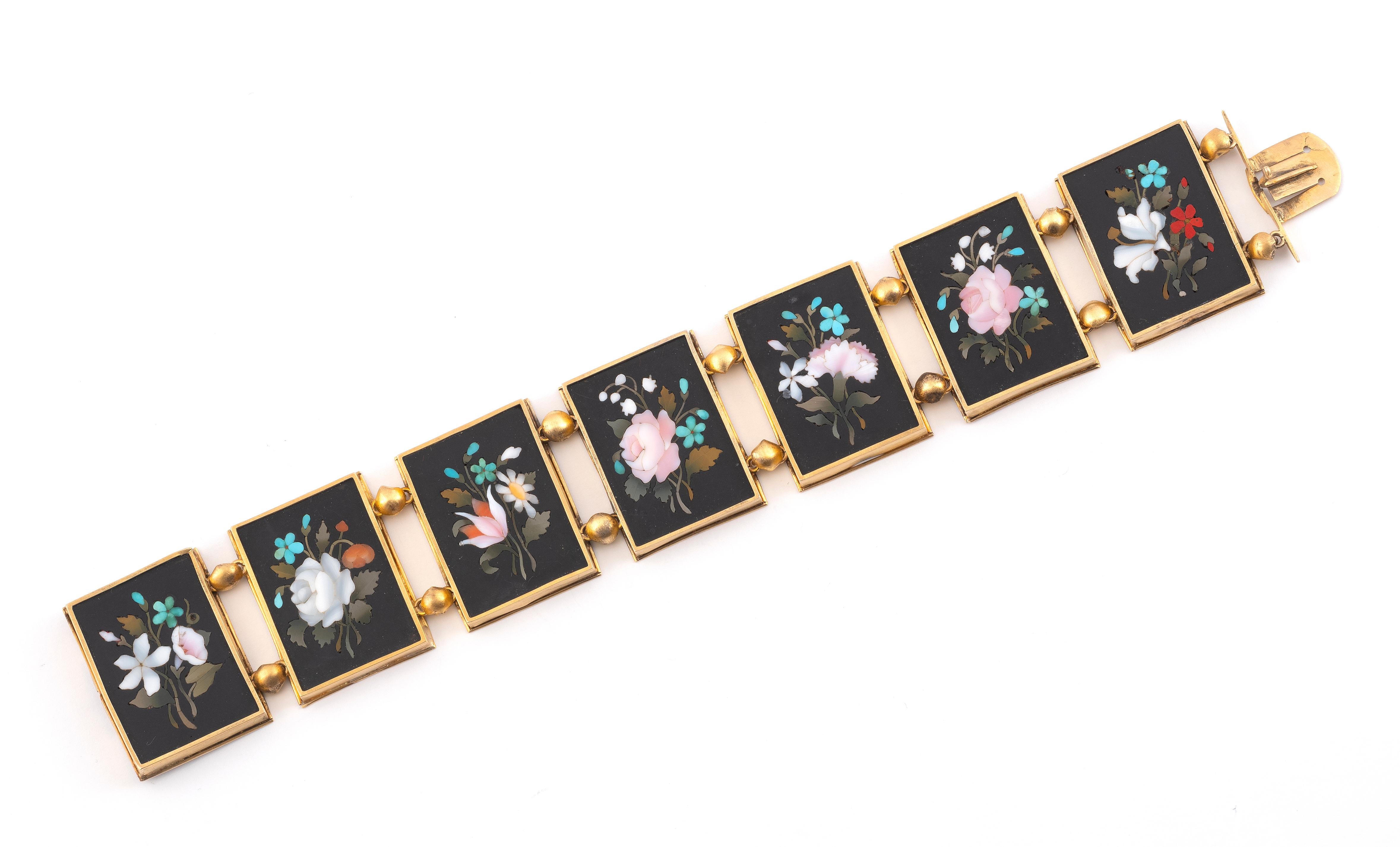 Composed of seven rectangular panels of pietra dura depicting flowers, each within a gold frame with plain decoration, connected by gold half round, late 19th Century, 17 cm long 
With Asprey box.