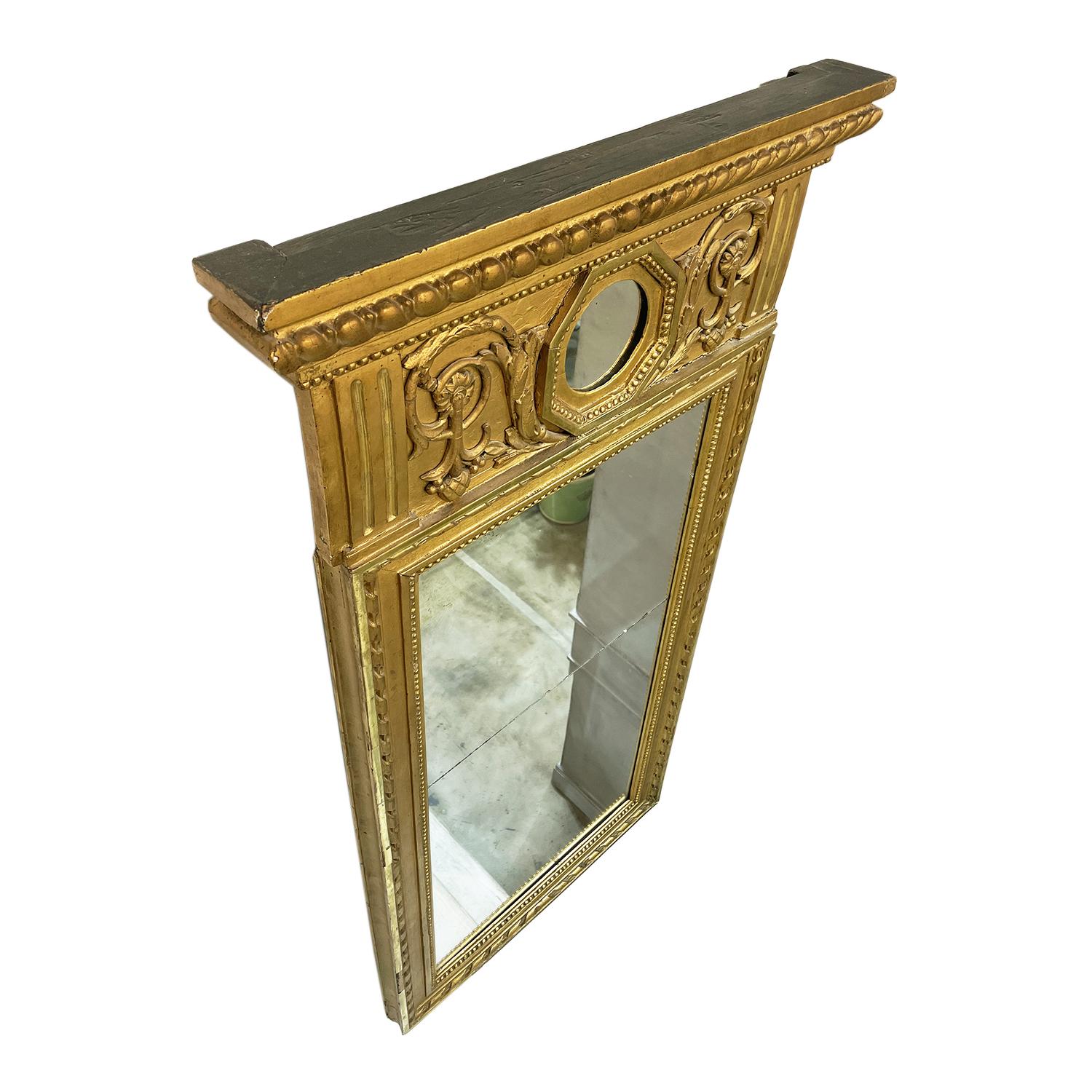 A gold, 19th century Swedish Gustavian wall mirror made of handcrafted gilded Pinewood, in good condition. The antique Scandinavian mirror is particularized with medallion and it is consisting its original mirrored glass. Wear consistent with age
