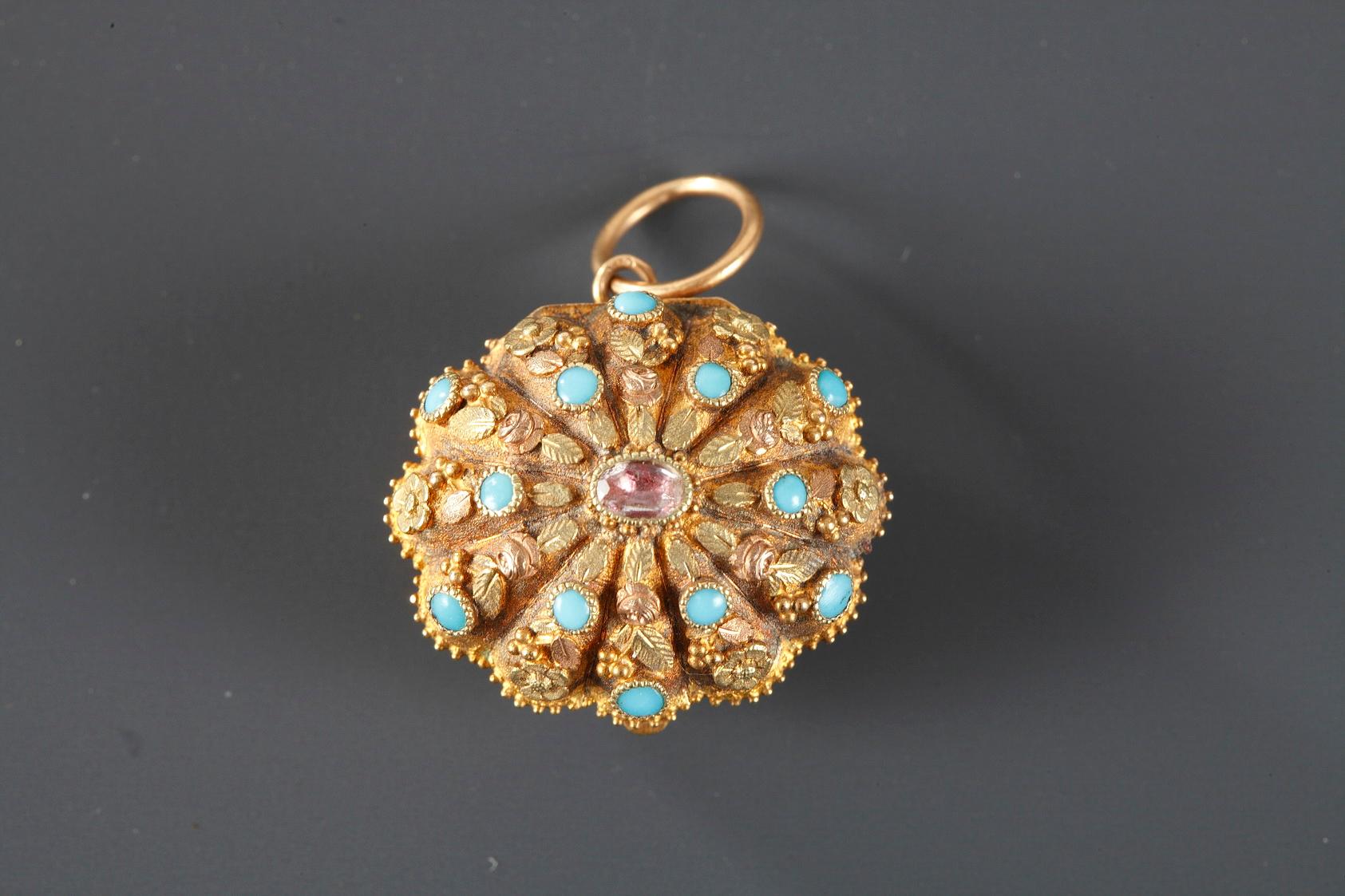 A shell-shaped vinaigrette finely chiselled with flowers and seeds in two colours of gold. The lid is decorated with a ruby cabochon surrounded by small beards of turquoise. Interior openwork railing for flavours, adorned with foliages.
French mark