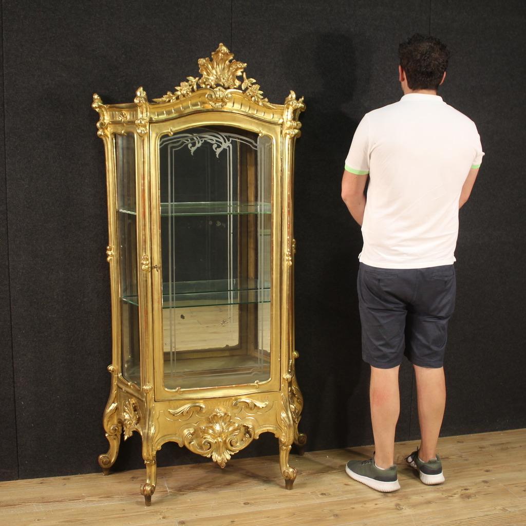 Italian showcase from the end of the 19th century. Furniture in finely carved and gilded wood and plaster of beautiful lines and pleasant furnishings. Display cabinet with one door internally equipped with two glass shelves and mirrored bottom (not