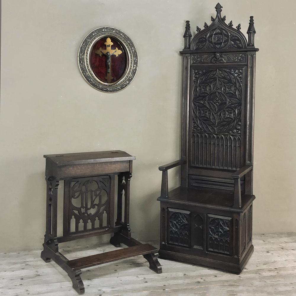 19th century Gothic Cathedral chair is a masterful study in the style, with hand carved magnificence appearing from the arched seatback crown above to the cabinet front below! Intricately sculpted spires and geometric molding centered with a beloved