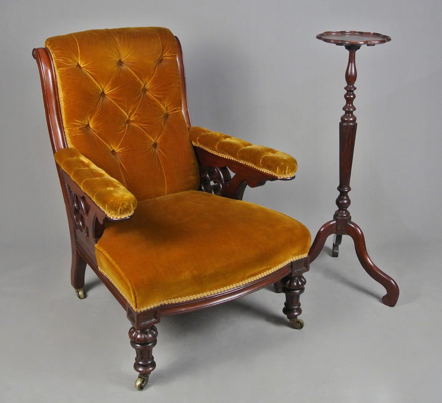 A very attractive and comfortable fireside chair of exceptional quality in solid mahogany and carved with substantial gothic trefoils which form the arm supports.  Really beautiful large and well turned front legs set on original solid brass