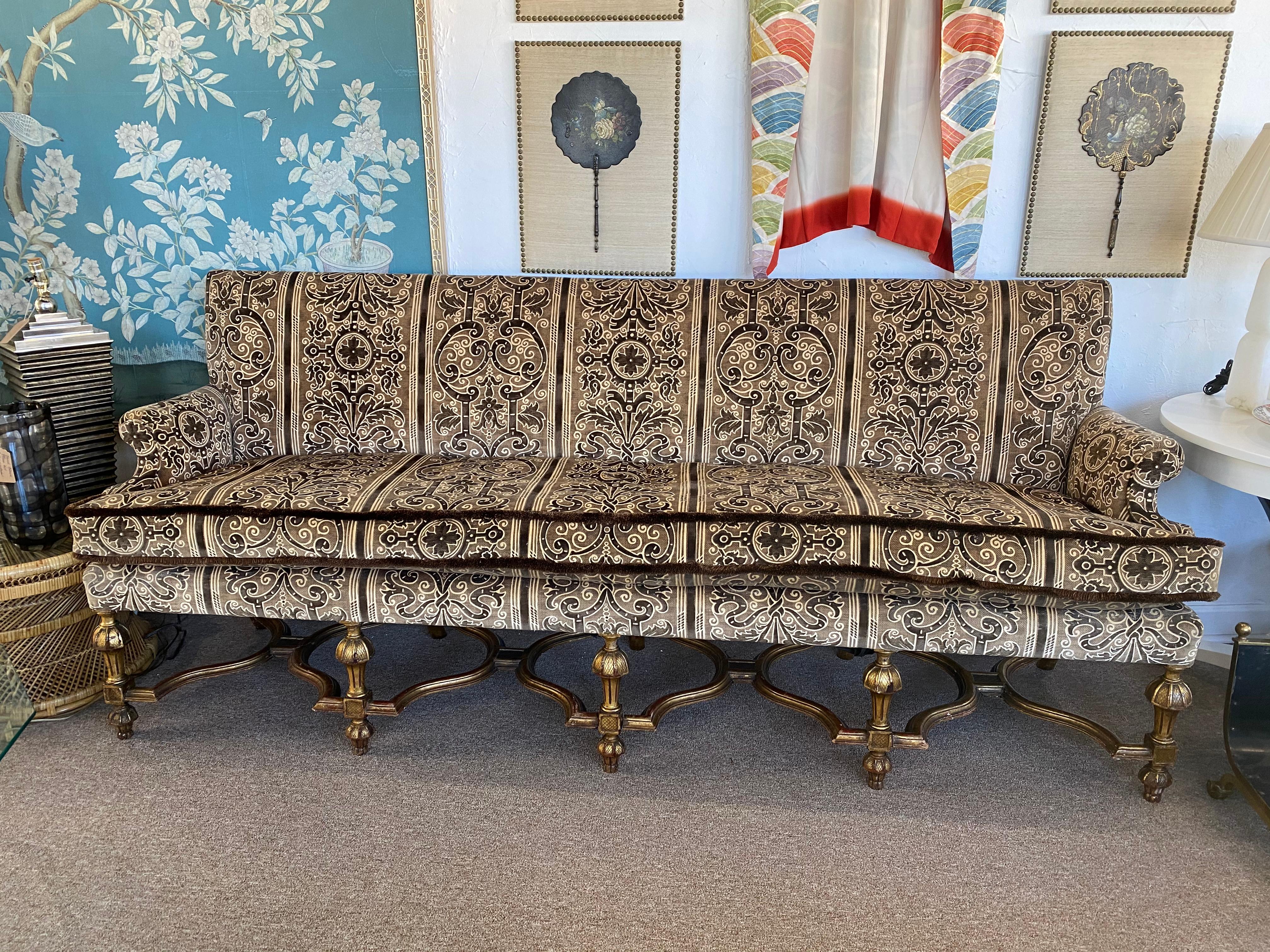 This large settee sofa is recovered in Bergamo Corded Velvet with brush trim. The gilded legs in the Victorian/Gothic pattern are stunning. Great condition!