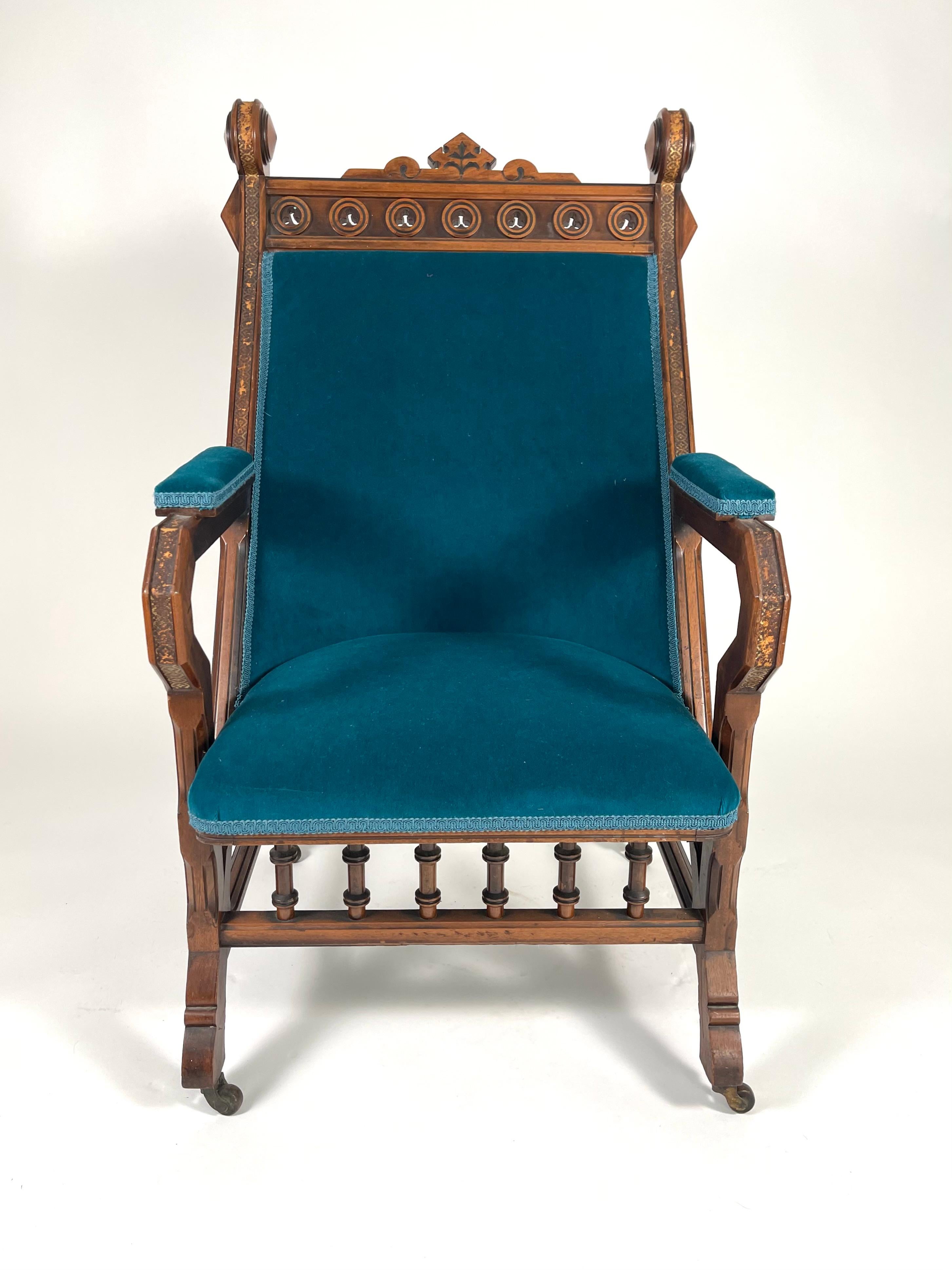 Gotischer Revival-Sessel aus geschnitztem Nussbaumholz des 19. Jahrhunderts, gepolstert mit türkisfarbenem Samt von Holland und Sherry. Inspiriert durch japanisches Design und englische gotische Ornamente, ist die Wappenleiste mit Kreisen und