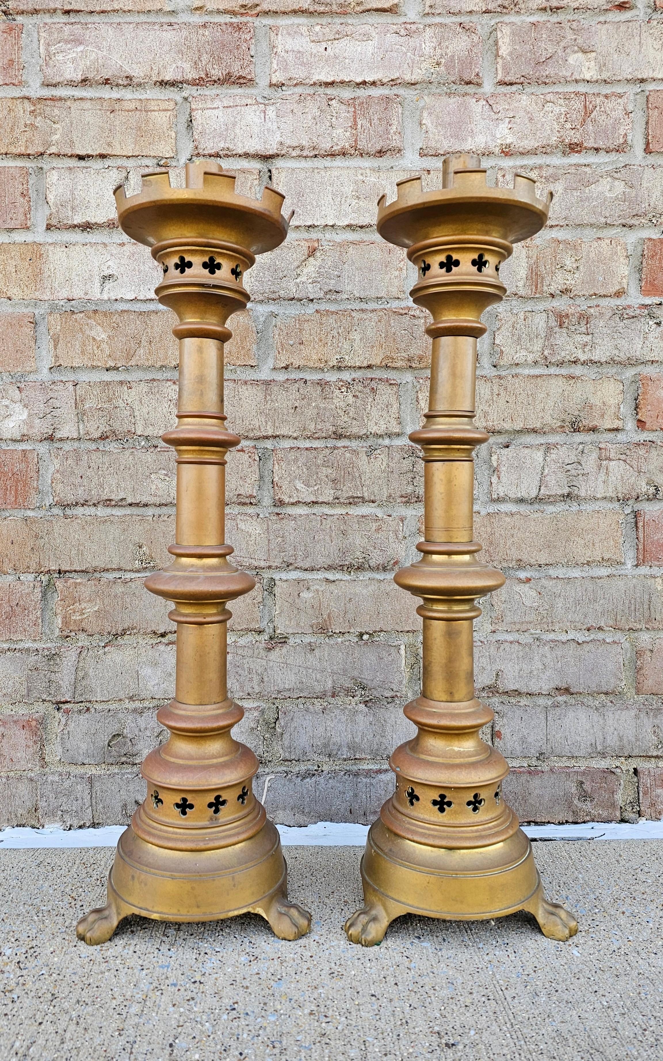 A stunning pair of antique Neo-Gothic bronze church altar stick candle prickets with beautifully aged patina. 

European, late 19th century, each with a single candle socket, mural crown, pierced quatrefoils, wafer stem, rising on paw feet.