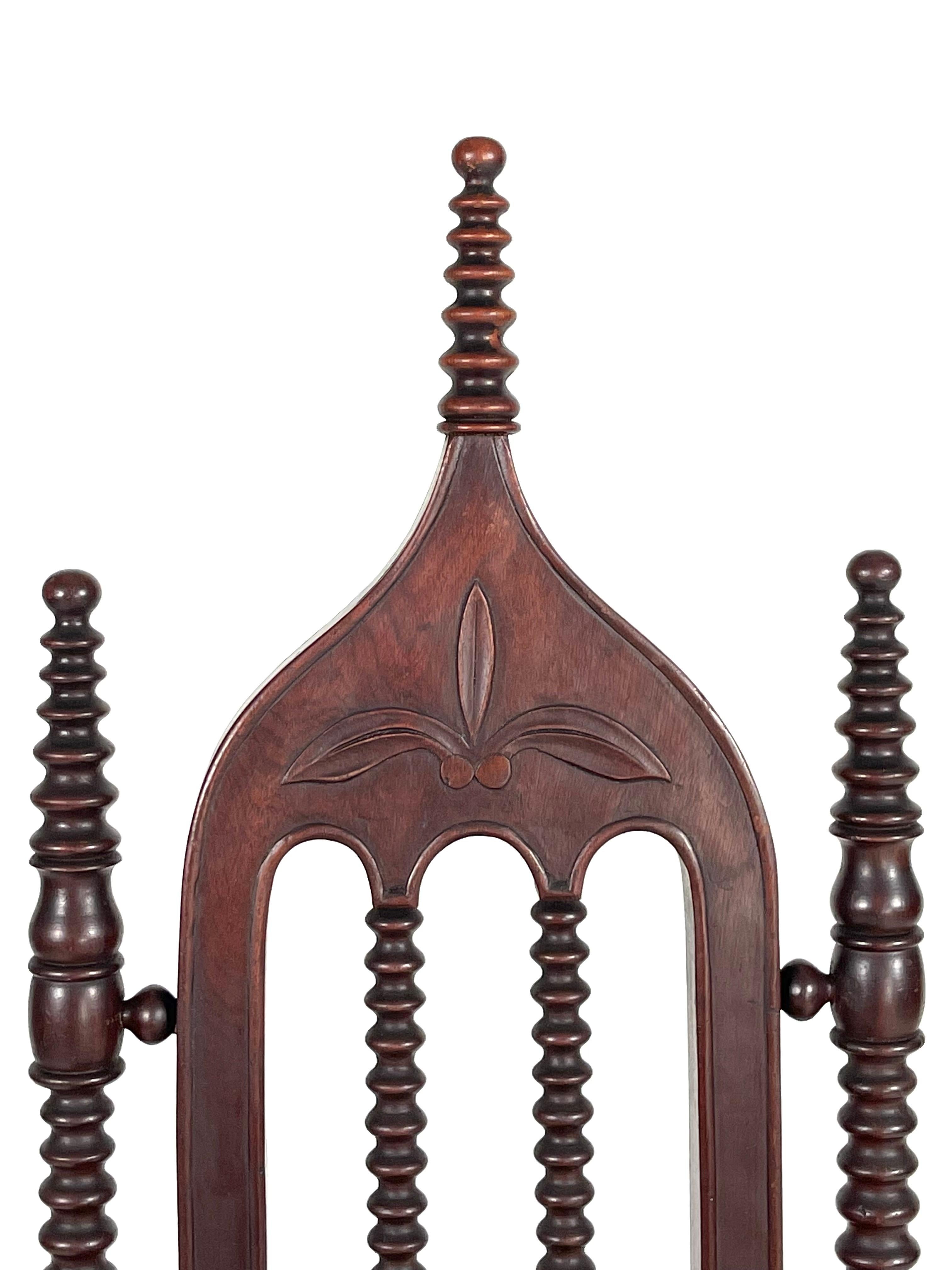 A 19th Century Gothic Revival side chair with ogee-arched back decorated with a carved stylized fleur-de-lys in the center and with turned “pinnacles” and legs. The seat is upholstered with hand block printed fabric made by a local artist.