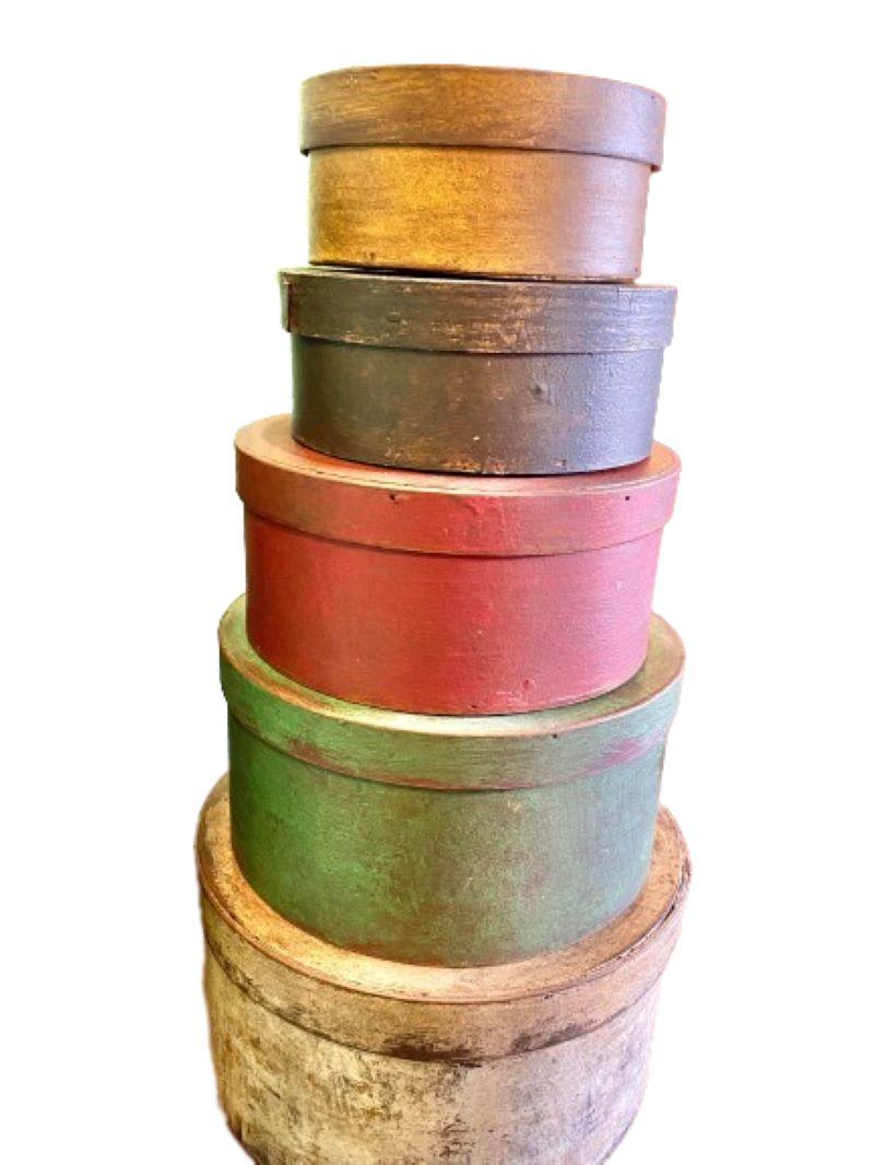 19th Century Graduated Stack of Paint Decorated Pantry Boxes, circa 1880, comprising five shaved splint bentwood pantry boxes with straight overlaps fastened via wooden pegs, in later distressed yellow, gray, red, green and white painted finishes,