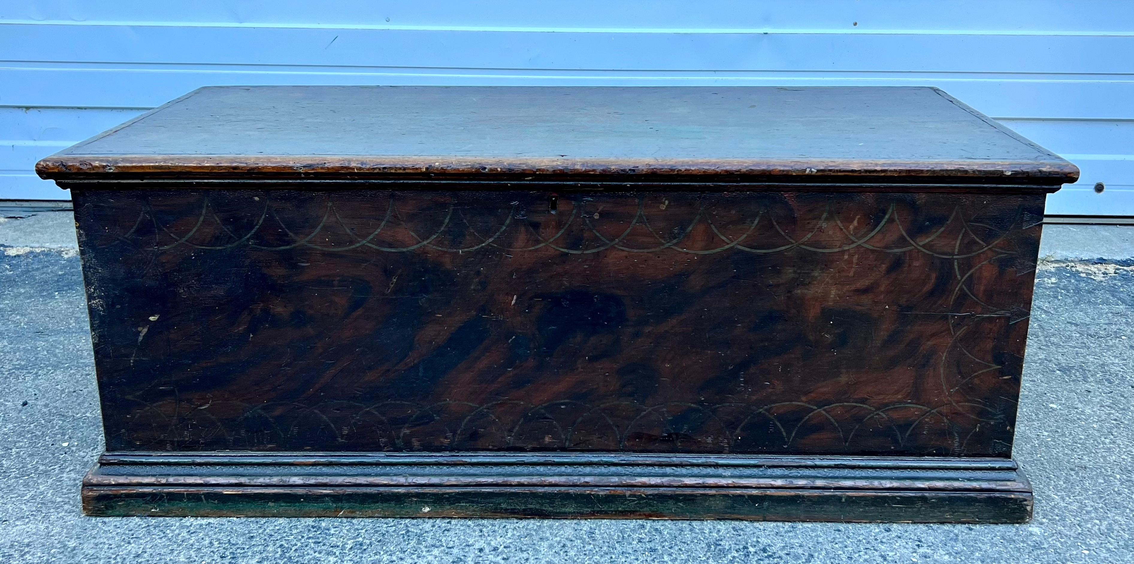 Deckentruhe aus Kiefernholz aus dem 19. Jahrhundert mit Spuren von blaugrüner und gemaserter Farbe sowie originalem vergoldetem Wellenschliffmuster.  Innenraum mit einfacher Klappe und schmiedeeisernen Bandscharnieren.  Kein Schlüssel.