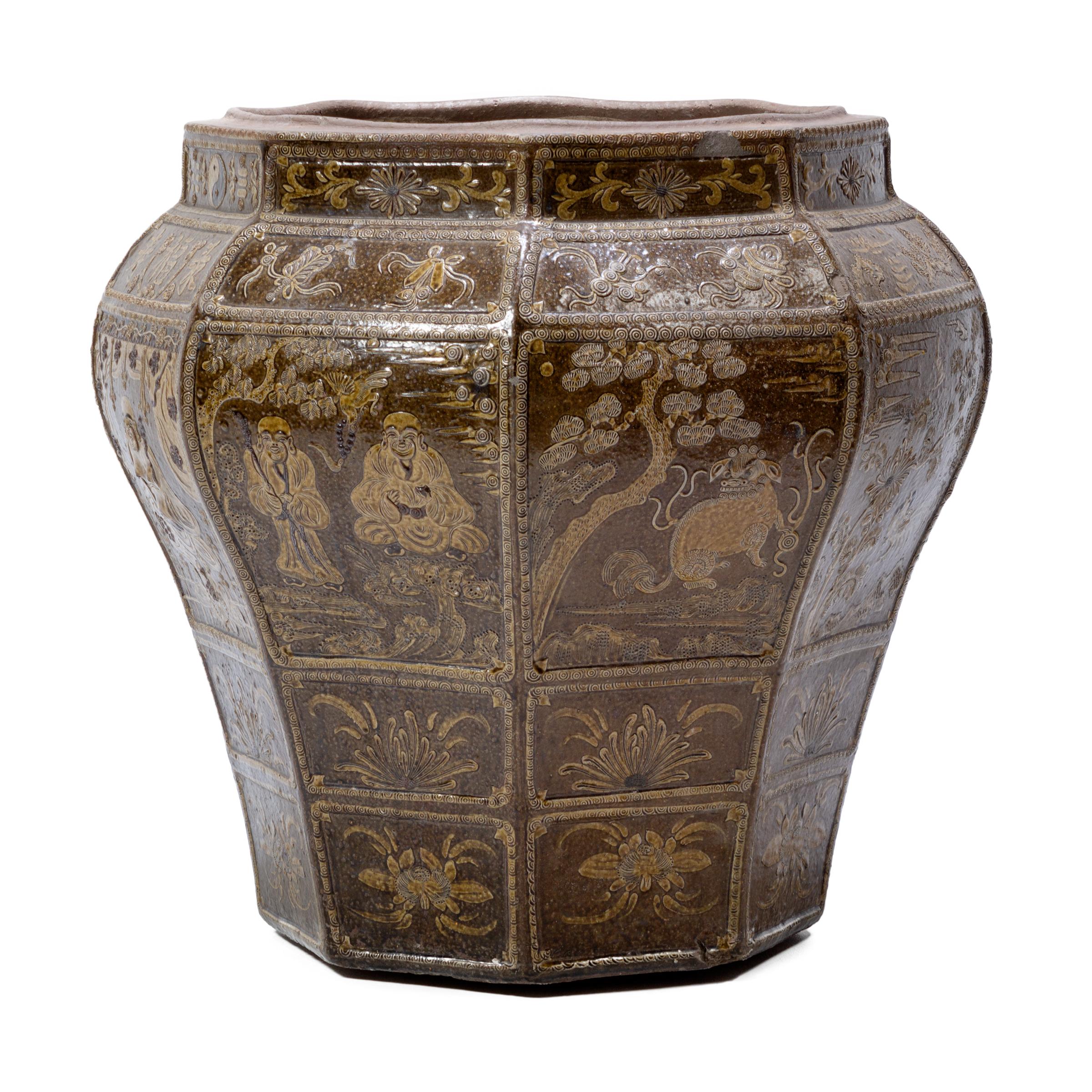 This monumental early 19th century finely glazed Chinese urn is eight-sided, an auspicious number of good fortune. Intricate paintings on its surface depict respected Taoist deities and immortals who redeem all creatures, as well as Taoist symbols