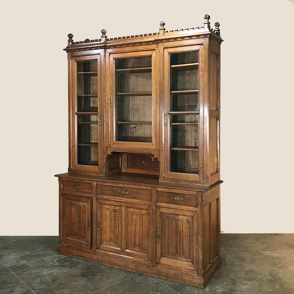19th century Grand Gothic bookcase was made by famed maker Emile Laurent-Durhesne of Liege, and features a restrained version of the style, with linen fold panels the primary visual motif. Exquisite detailing can be found in the finials and rosettes