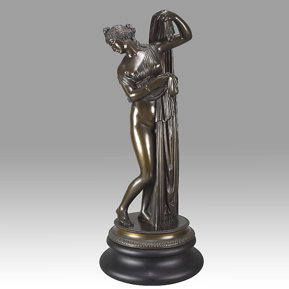 Beautiful Art Nouveau period classical bronze study of a partially draped woman, raising her light peplos (draped clothing) to uncover her hips and buttocks, and looking back and down over her shoulder, perhaps to evaluate them. This subject is