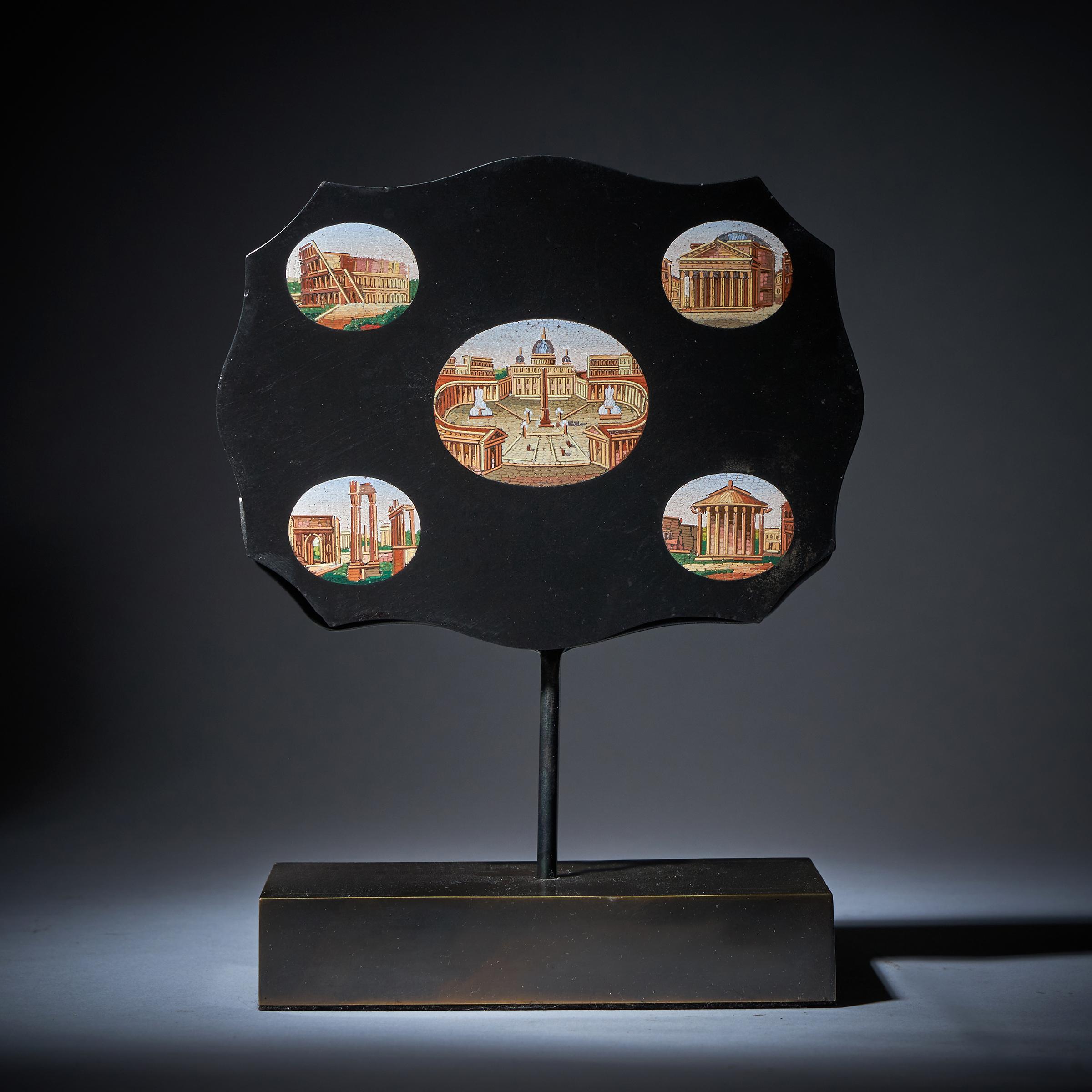 Fina tablilla o pisapapeles de micromosaico de serpentina de mediados del siglo XIX que representa el emblemático Vaticano de San Pedro, el Coliseo de Roma, el Panteón, las ruinas del Foro Romano y el Templo de Vesta, en mármol negro, elevado sobre