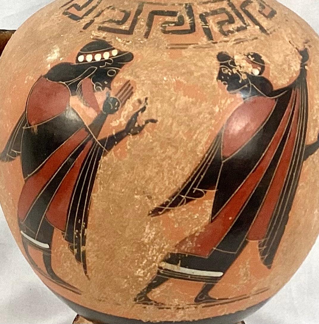 Late 19th century Grand Tour style terracotta vessel decorated with red and black Grecian figures with Amphora form, three handles on neck (two on side, one in back). Hand painted.

Dimensions:
10
