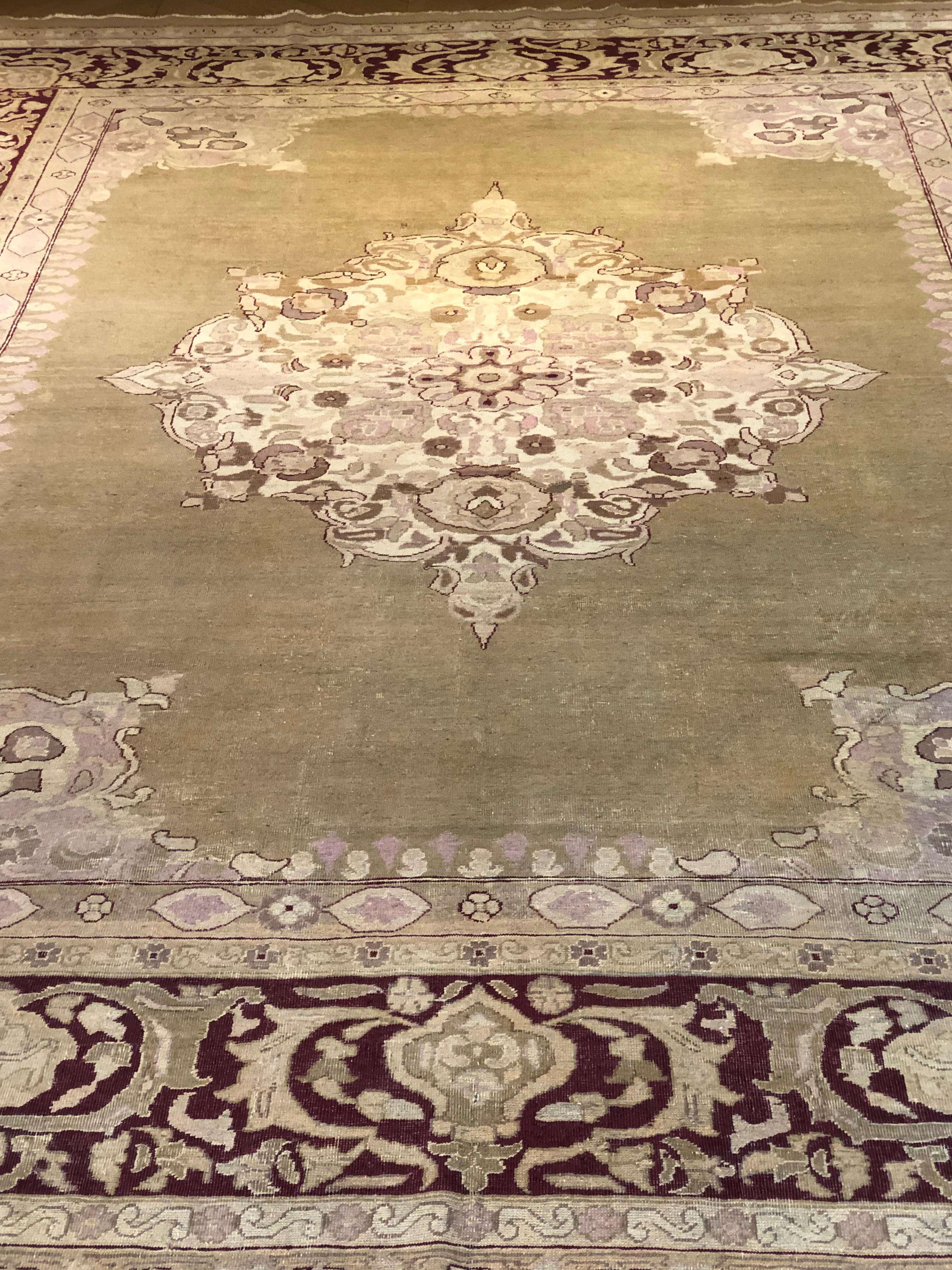 Indian production carpet with pastel tones. A large beige medallion rests in the green lemon-coloured field. The rich border has a purple-red background and is decorated with small sweaters that recall the central one. Measures: 340 x 270 cm
This