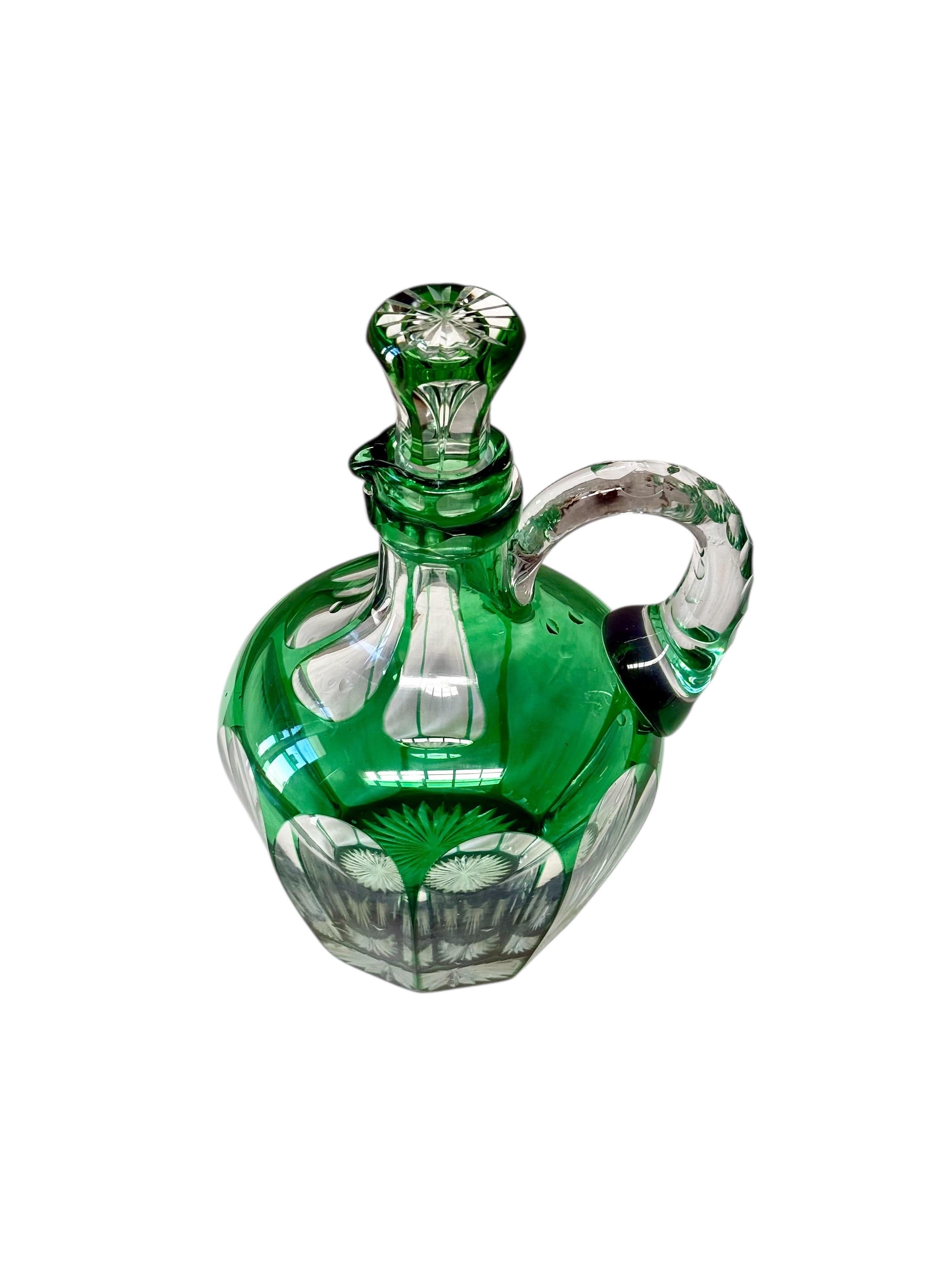 A superb example of 19th-century European glass artistry, this green overlay crystal decanter embodies refinement, balance, and craftsmanship at its finest. The deep emerald overlay, hand-cut to reveal the brilliance of clear crystal beneath,