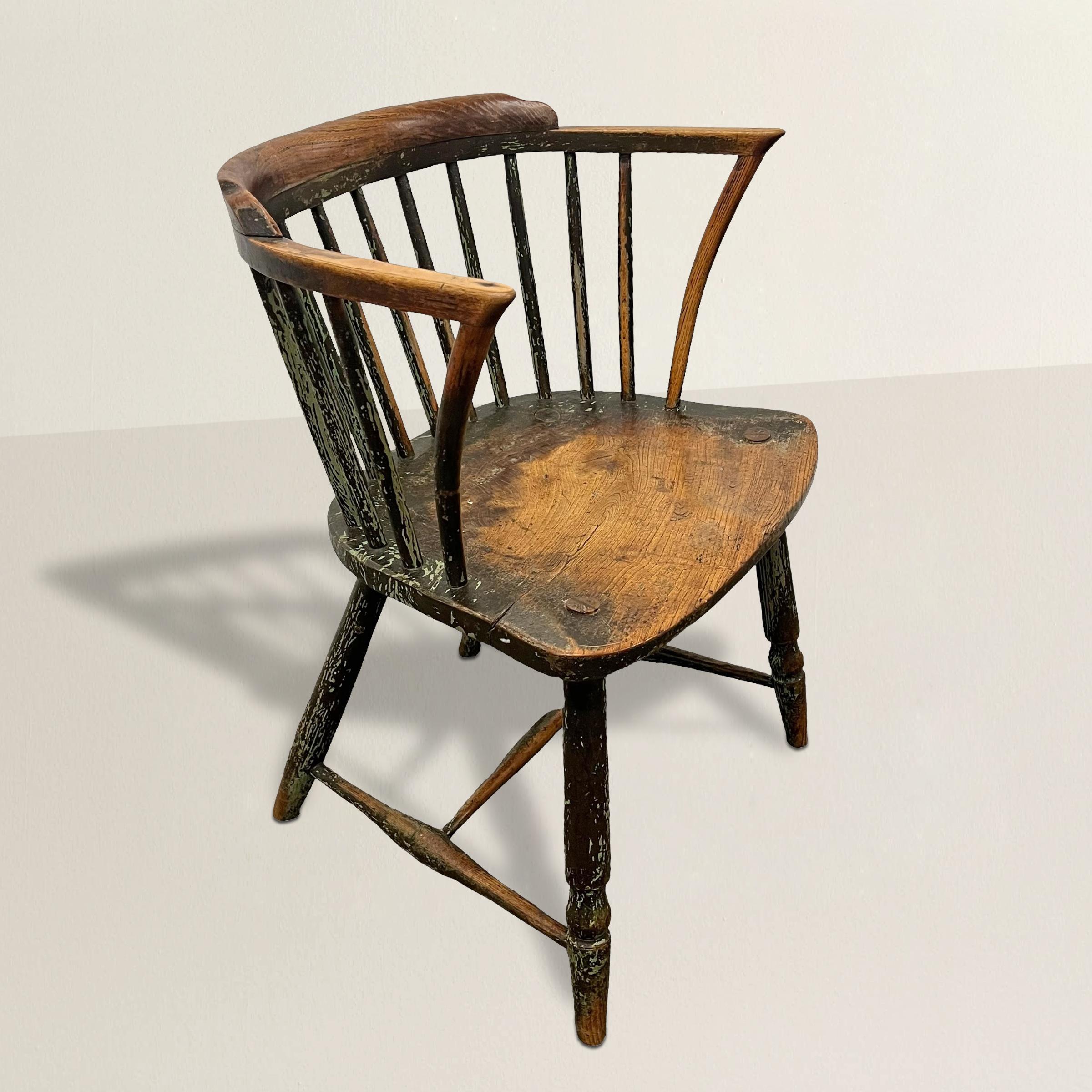 Cette charmante chaise Windsor anglaise à dossier bas du milieu du 19e siècle est un véritable bijou d'artisanat ancien. La traverse de la chaise en bois d'if courbé, gracieusement incurvée et soutenue par un agencement rythmique de fuseaux, crée