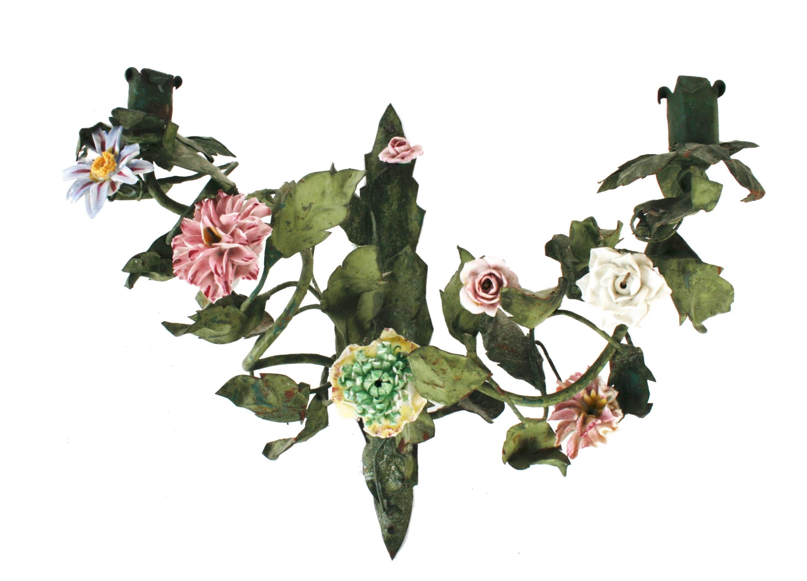 A pretty pair of French green tôle sconces with two branches of hand-painted faience porcelain flowers and metal leaves. The two branches have tole candle holders and are supported on an acanthus leaf bracket. A unique pair for a pretty place.
N.P.