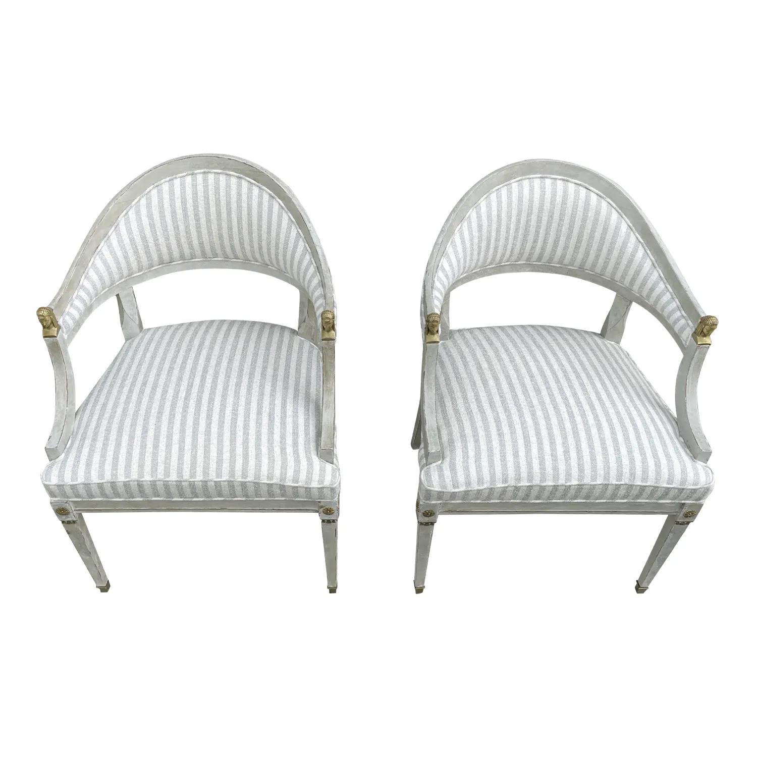 A light-grey, antique Swedish Gustavian pair of armchairs made of hand carved pinewood, in good condition. The Scnainaivan side chairs have an open, oval backrest with slim, arched armrests, detailed by hand crafted bronze sculptures, ladies and