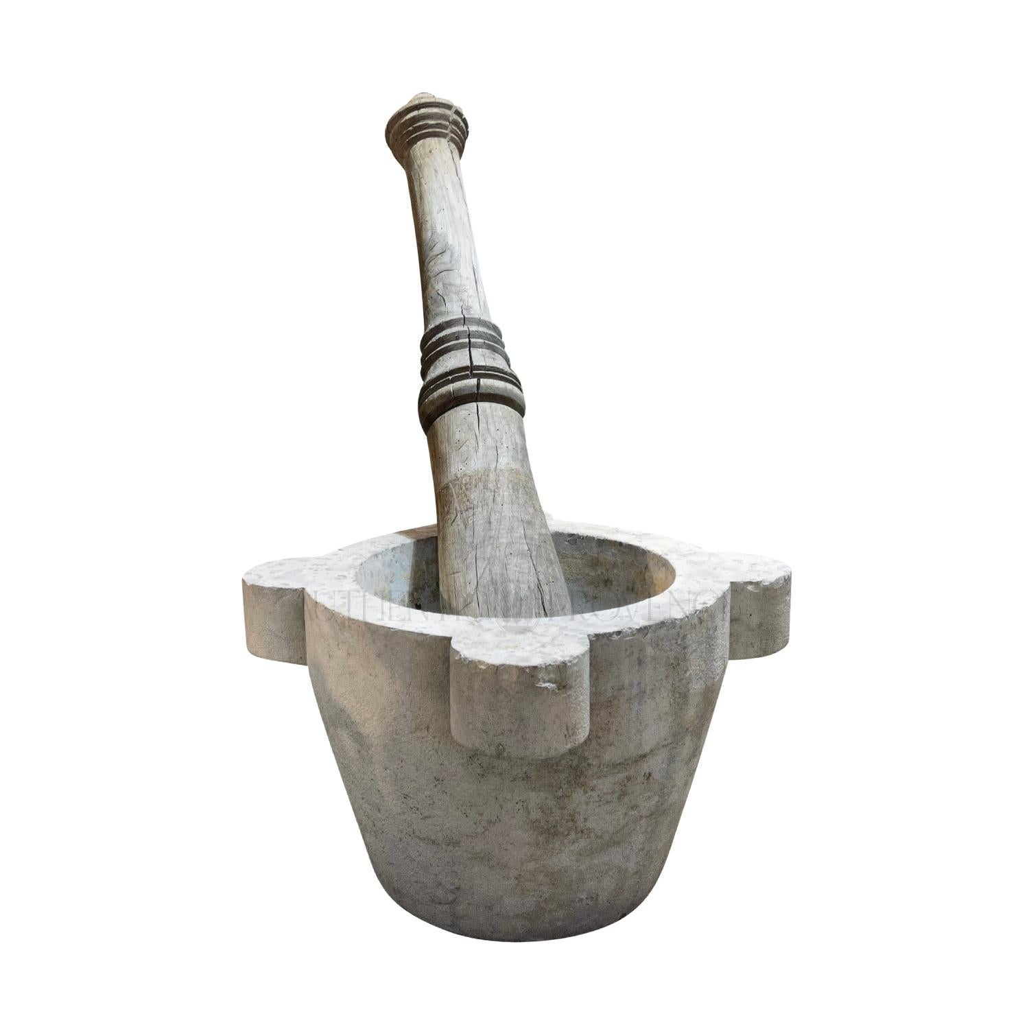 Early 19th century, a set of an oversized mortar made of hand crafted white marble with a wooden Oakwood pestle, in good condition. This fun set was on display in a pharmacy in Milan. These simple tools have been used from the Stone age to the