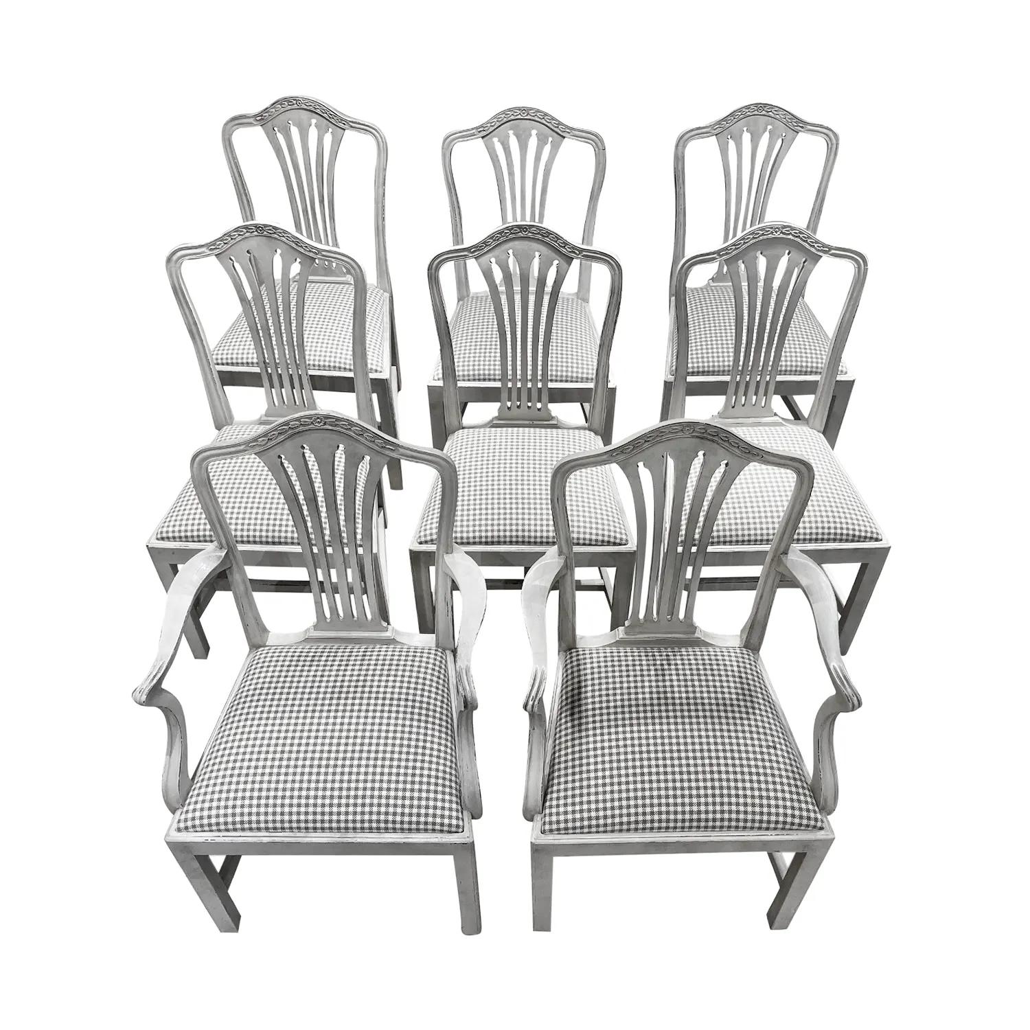 An antique Danish set of six side chairs and two armchairs in a chalky grey finish made of hand crafted Pinewood, in good condition. The Scandinavian chairs have a rounded backrests and a centered floral decoration, possibly Denmark. The seats have