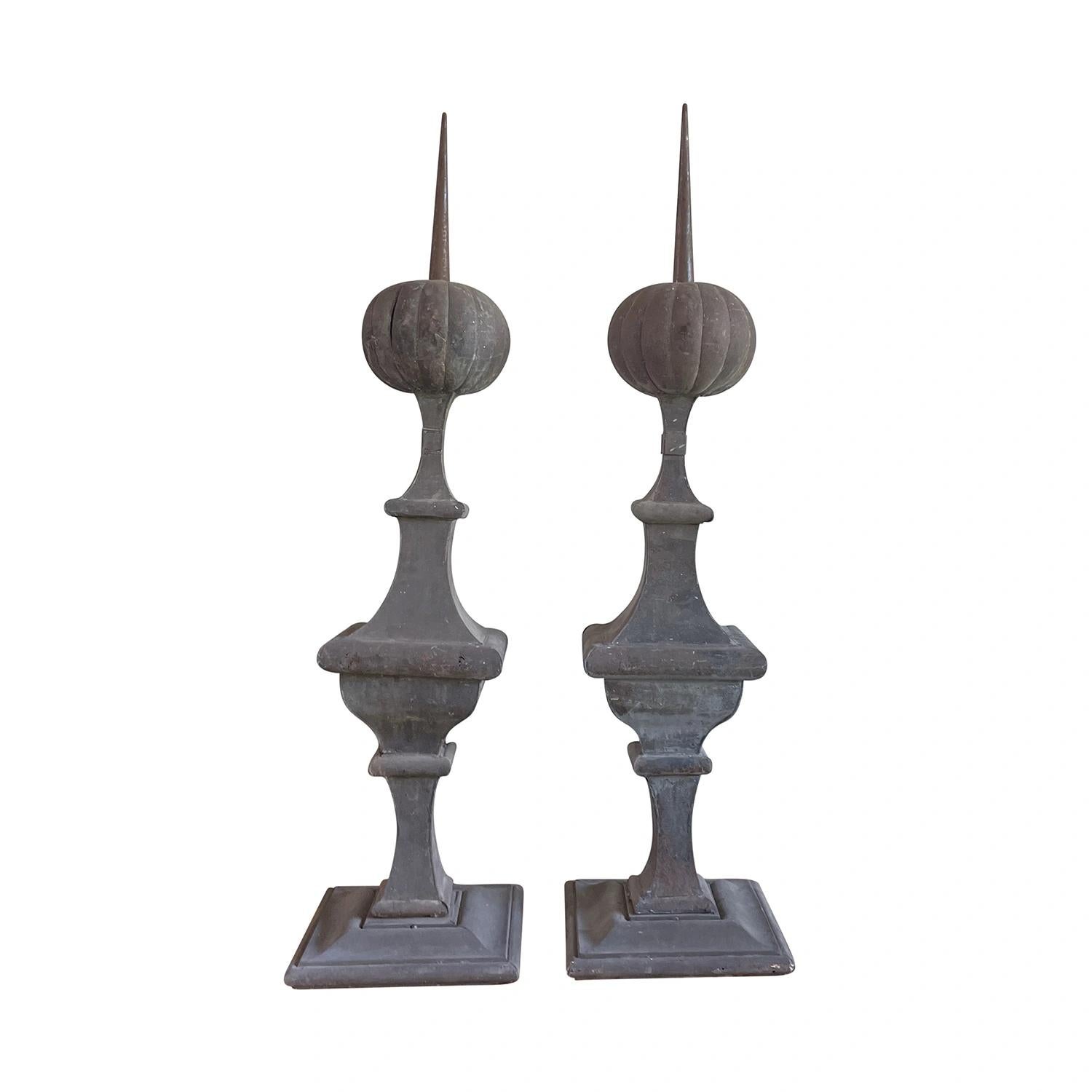 A grey pair of oversized French antique finials made of hand crafted zinc from an estate in Avignon, France, in good condition. These decorative ornaments have a baluster shape and sit on a square base. This set was originally installed as a