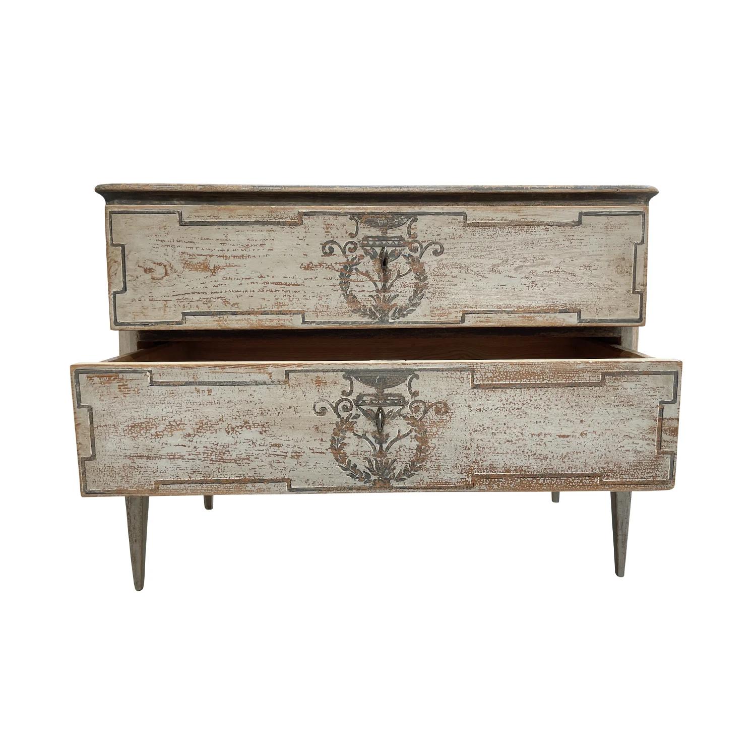 A light-grey, antique German Biedermeier single commode made of hand crafted painted Pinewood, in good condition. The chest is composed with two large drawers, consisting its original hardware and keys. The cabinet is standing on four skinny wooden