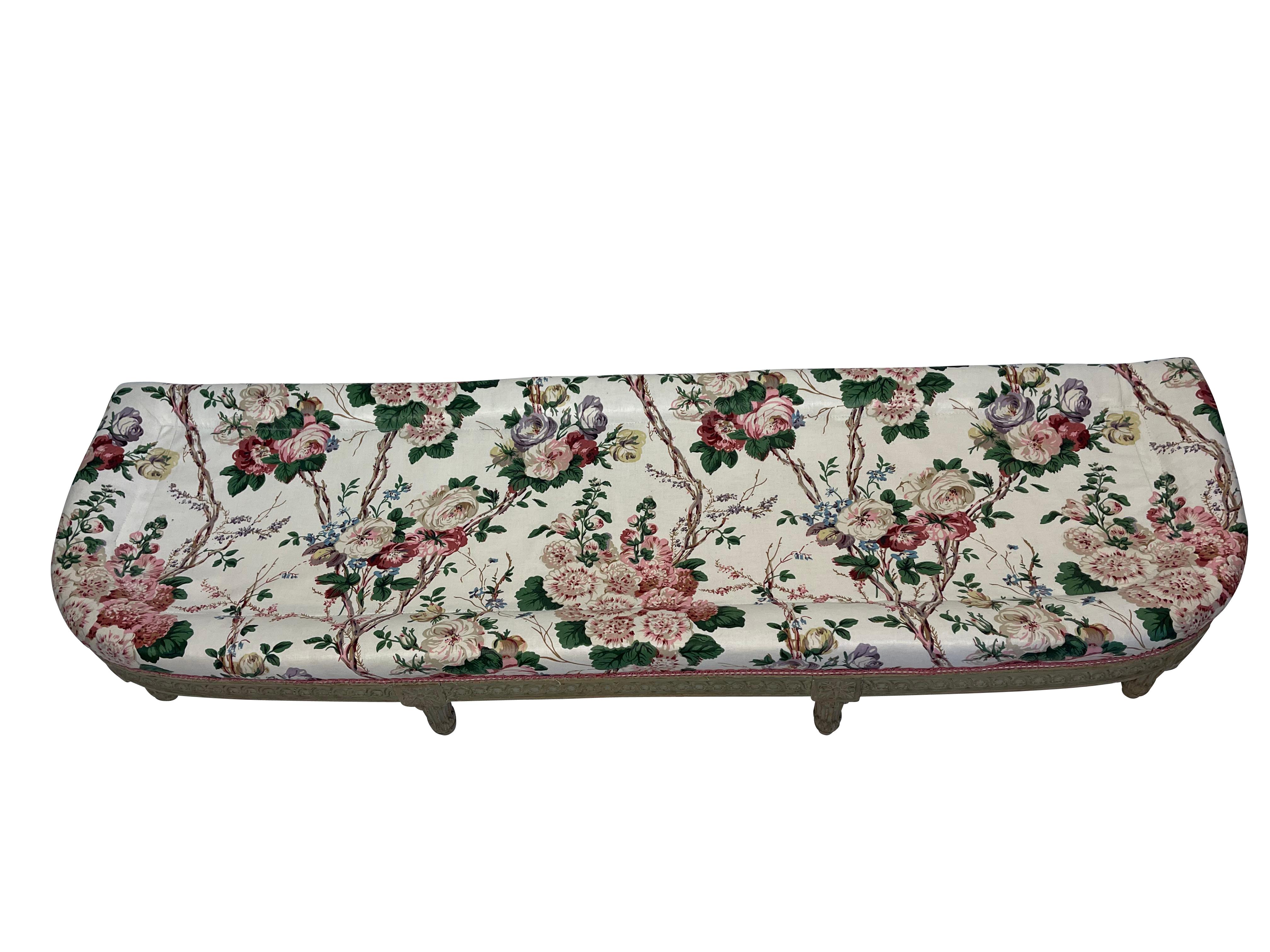 Grey-painted Louis XVI-style curved end of bed or fireside bench ready to be reupholstered in your choice of fabric.  It is upholstered in a polished chintz with a large goose-down pillow on top. The curved design has a straight back to fit against