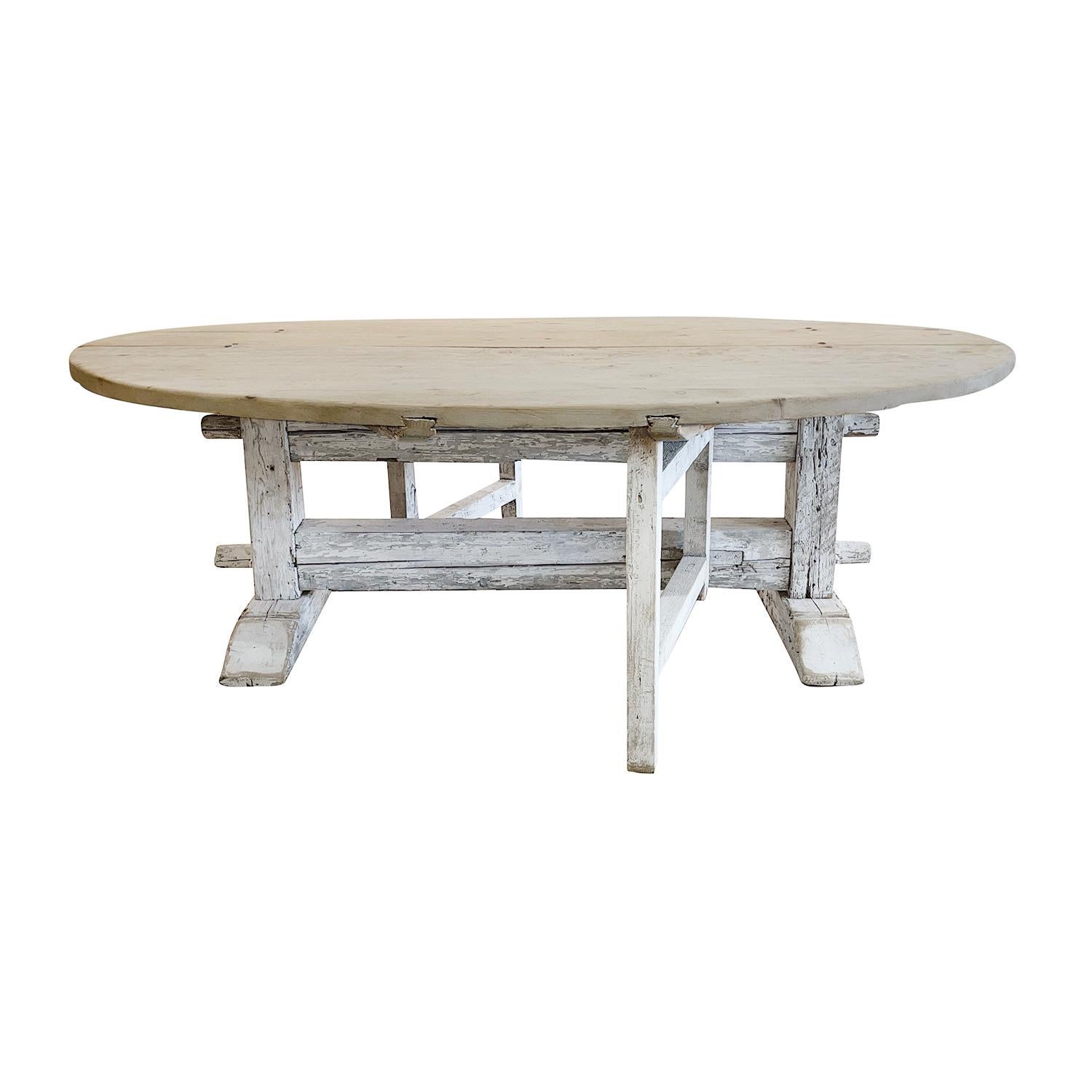 An antique grey white painted oval folding table with a massively constructed with trestle designed support, made of hand carved Pinewood, in good condition. This table seats eight. Wear consistent with age and use. Circa 1900, Italy.

Measures: