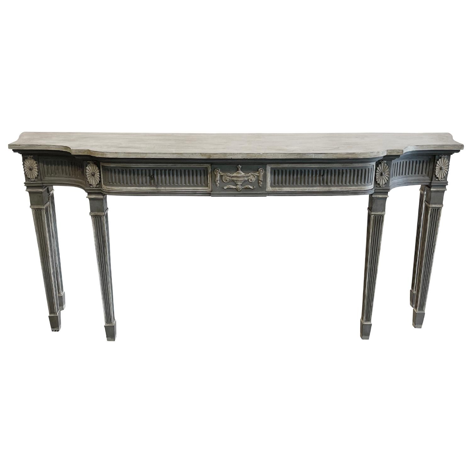 An 18th century style Scandinavian console table in a grey white finish, composed with its original brass hardware and key. The apron is centered with a classical urn and drapery tablet finish is carved from the solid plaque, in good condition.