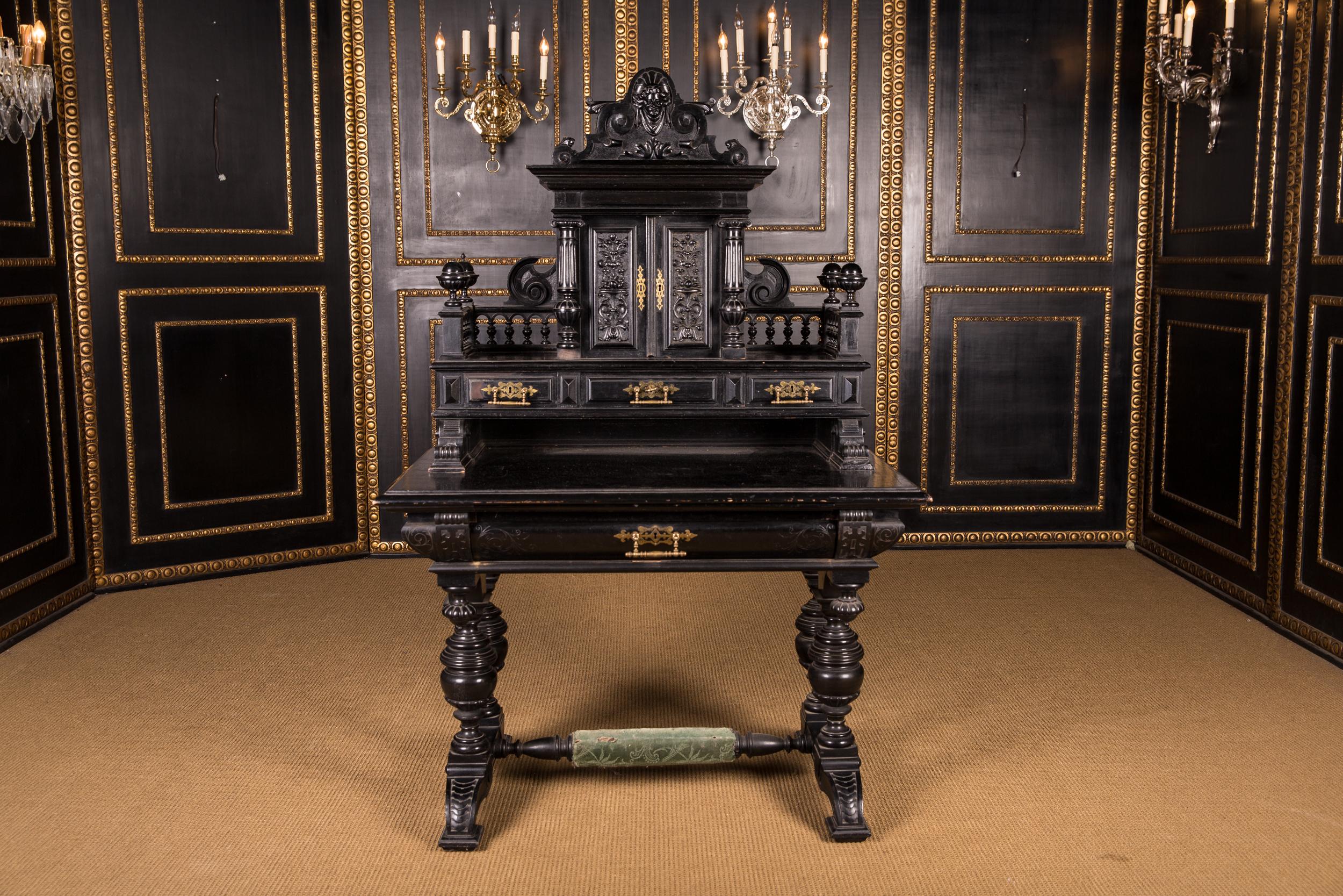 Richly carved, solid oak. Front high knee compartment with richly carved drawer, above a retractable writing compartment upholstered in leather, connected by a bridge on strong turned ball-shaped columns. Slightly overhanging tabletop, strongly