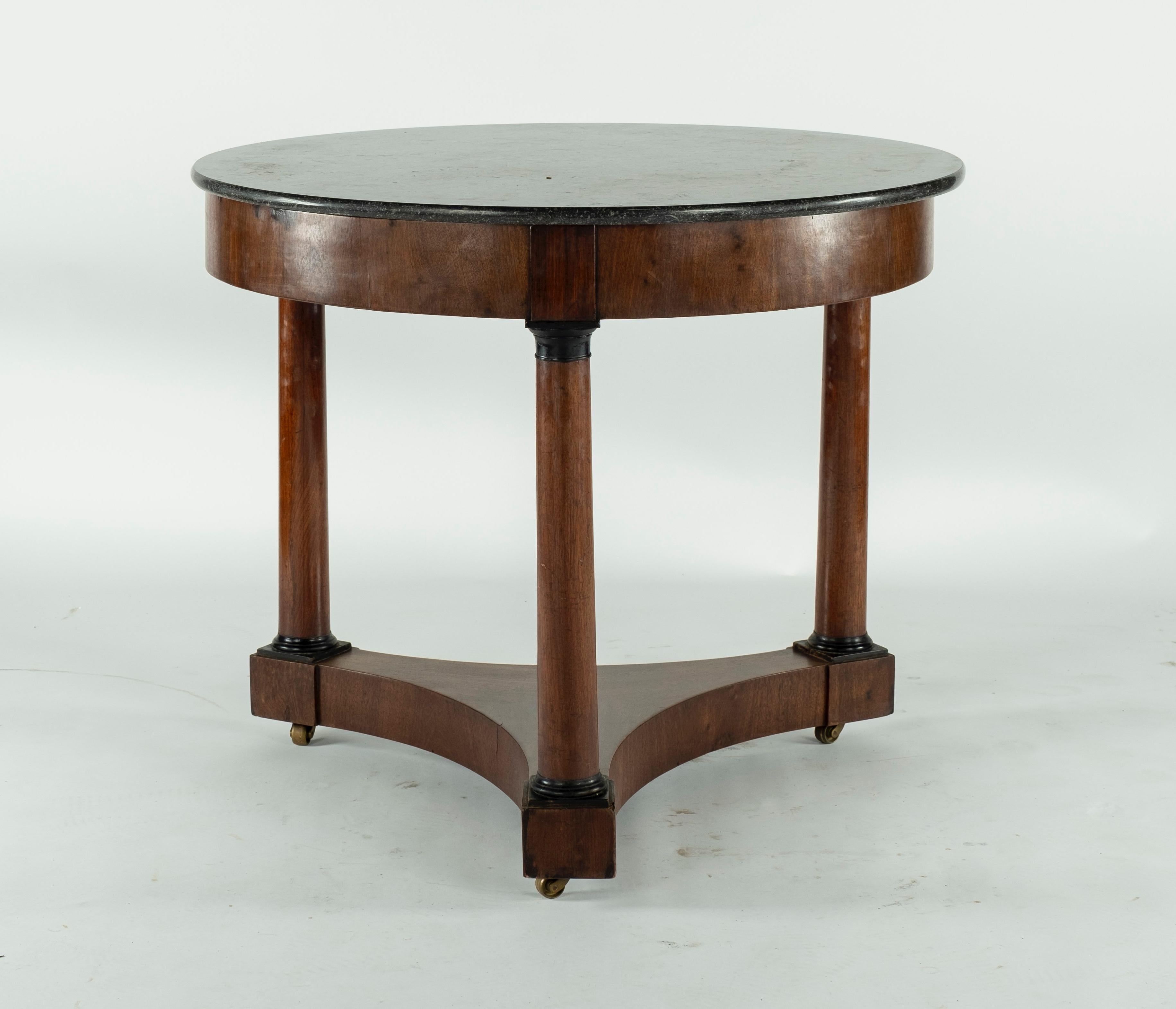 19th century beech gueridon with 3 legs on wheels. Legs are detailed with black lacquer at the top and at the base of each column.