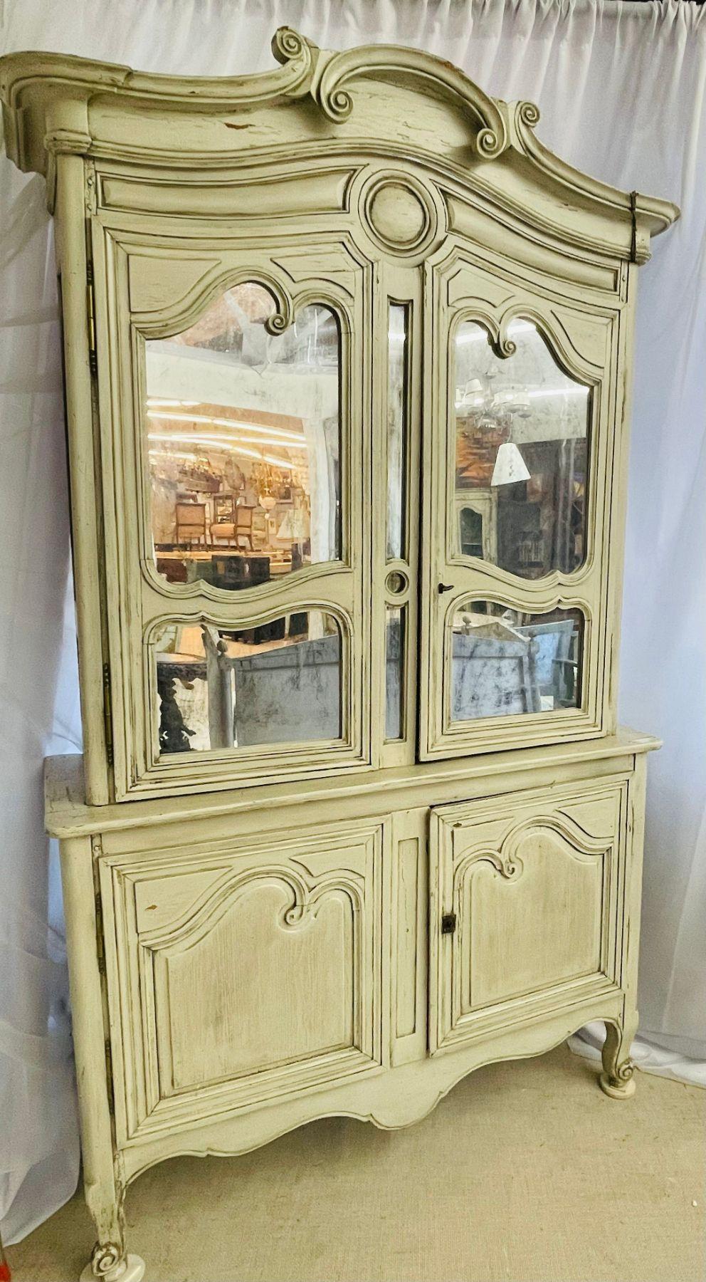 Gustavian bookcase cabinet, cupboard. 19th Century painted carved wood having antiqued mirrored door fronts. A fine French cabinet with mortise and tenon construction. Louis XV in Style with an original paint finish. 
Original paint. Gustavian
