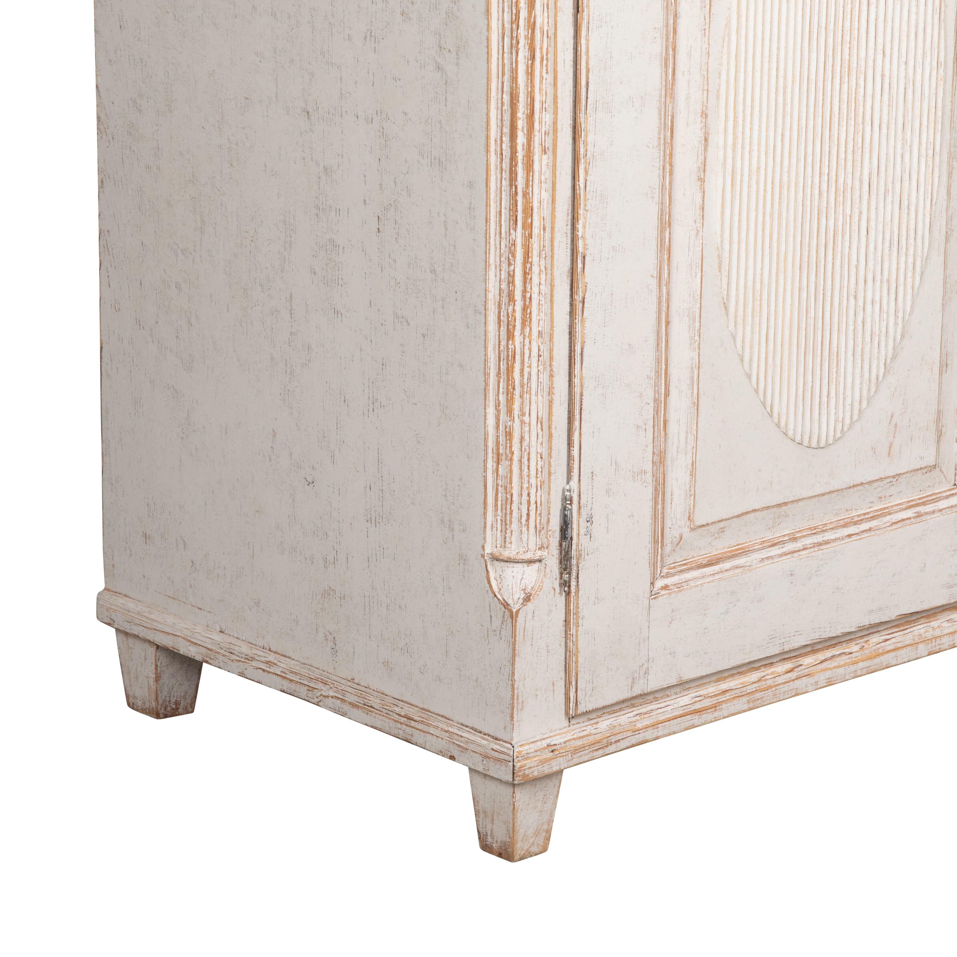 19th Century Gustavian dresser from Varmland Sweden.
Gallery top with two doors below featuring a decorative oval design.
The two doors open to shelved storage, and the outside of the piece has been repainted in a soft grey.