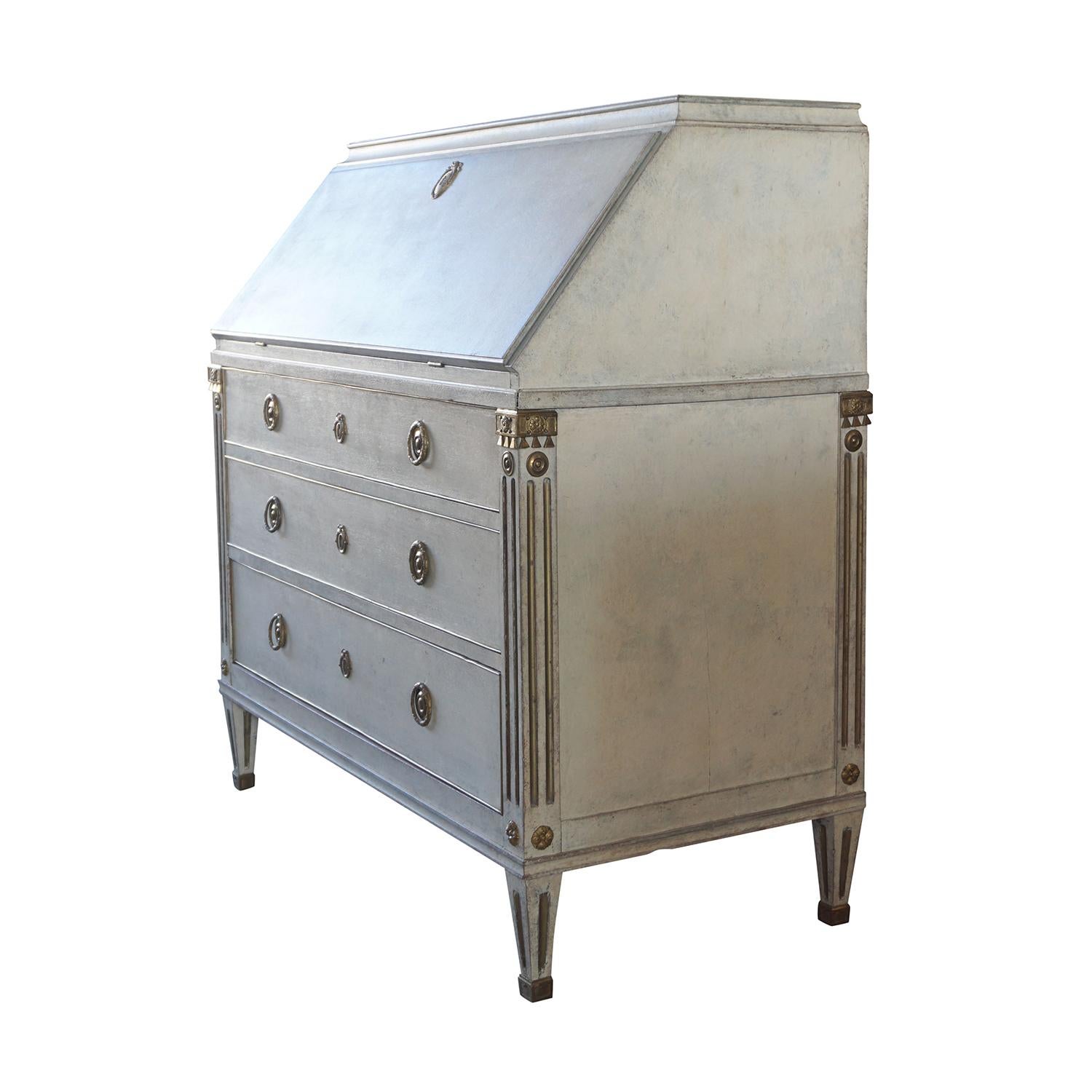 An antique Swedish Gustavian bureau, writing desk or table made of hand carved pinewood and bronze, enhanced by detailed brass decor inlay, in good condition. The light-grey Scandinavian fold out desk is detailed in the neoclassical Greek style with