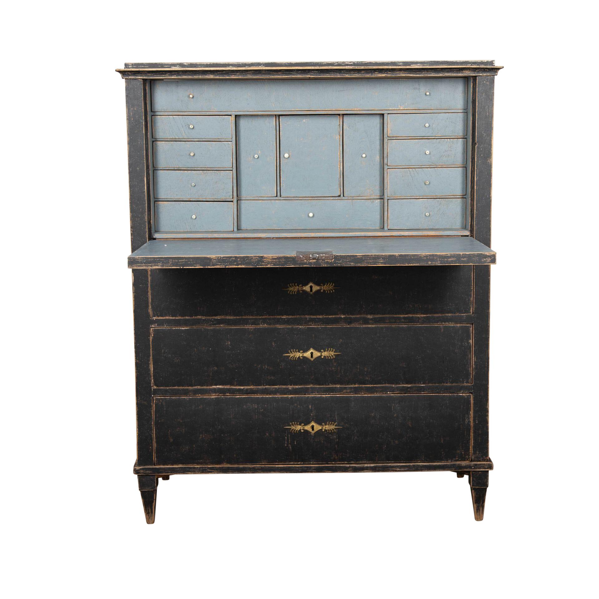 19th century Gustavian period desk, top section has a fall front, opening to a desk space and drawers, below three full width drawers.
Repainted in black its blue interior, original hardware.
