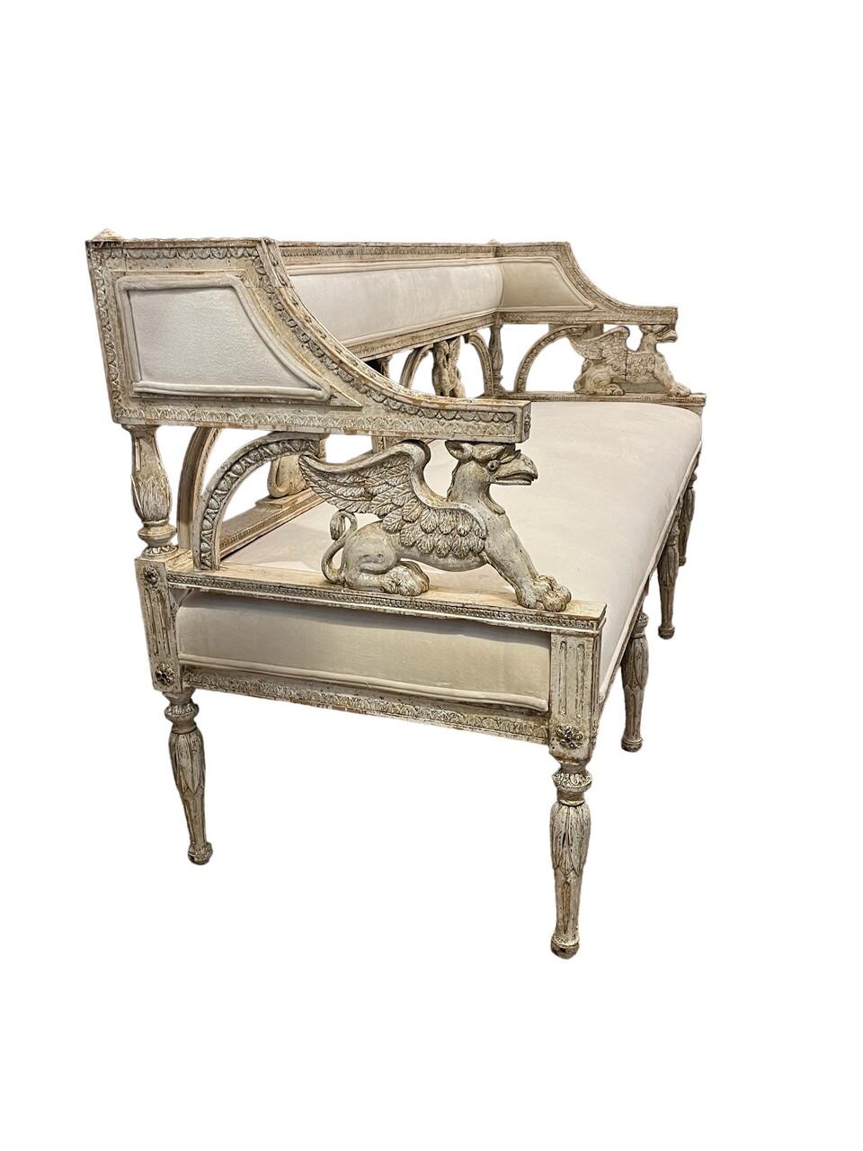 Banquette suédoise Gustavienne du 19ème siècle, nouvellement tapissée avec une finition peinte grattée à la main vers 1800. Elle présente des détails décoratifs sculptés, notamment des griffons. Cette pièce allie une élégance historique à un confort