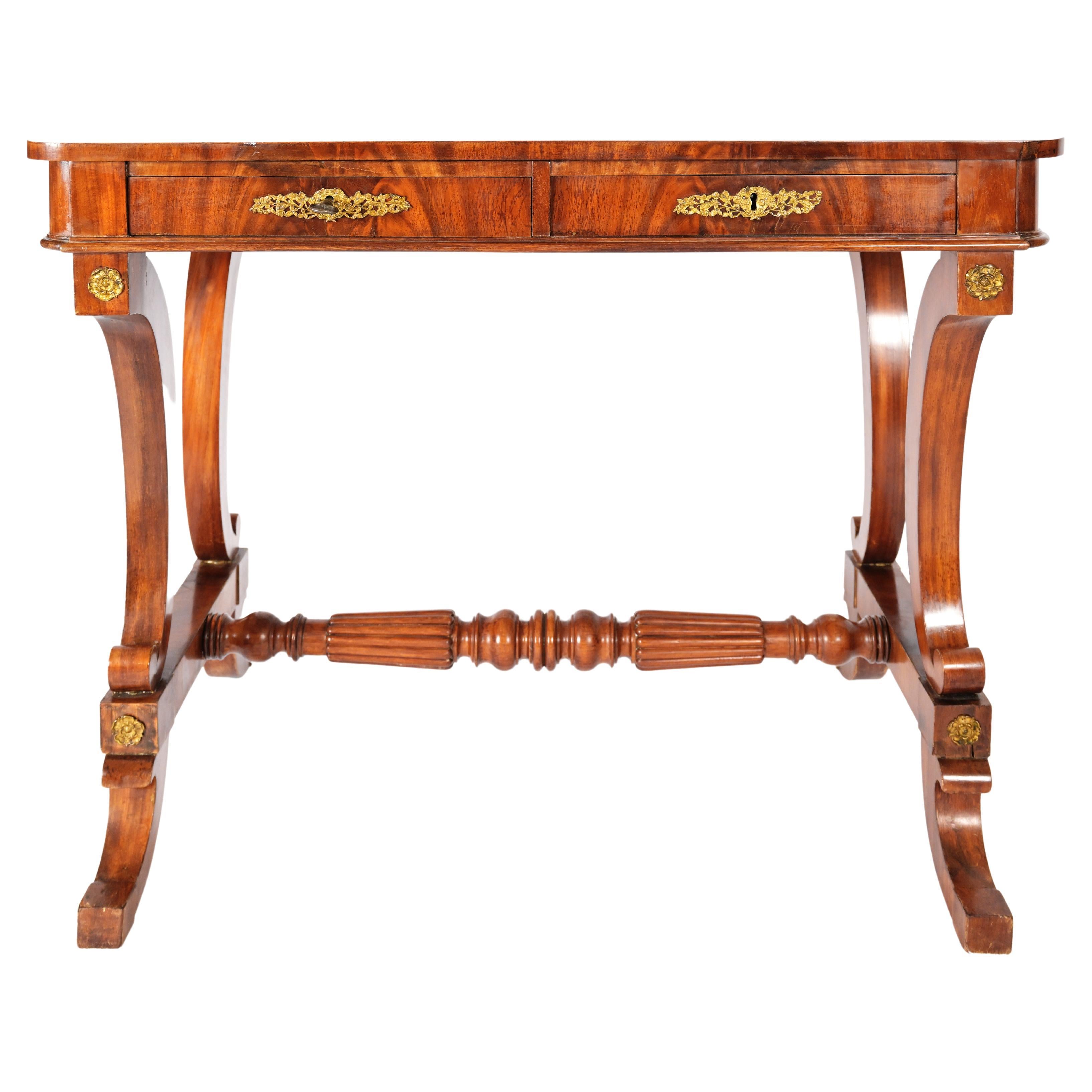 A 19th century writing desk by Swedish Master Cabinet Maker Johan Öman (1789-1833) who worked for King Charles XIV. The desk having two drawers with ornate brass frames along the locks. The square top with rounded corners rests upon two partially