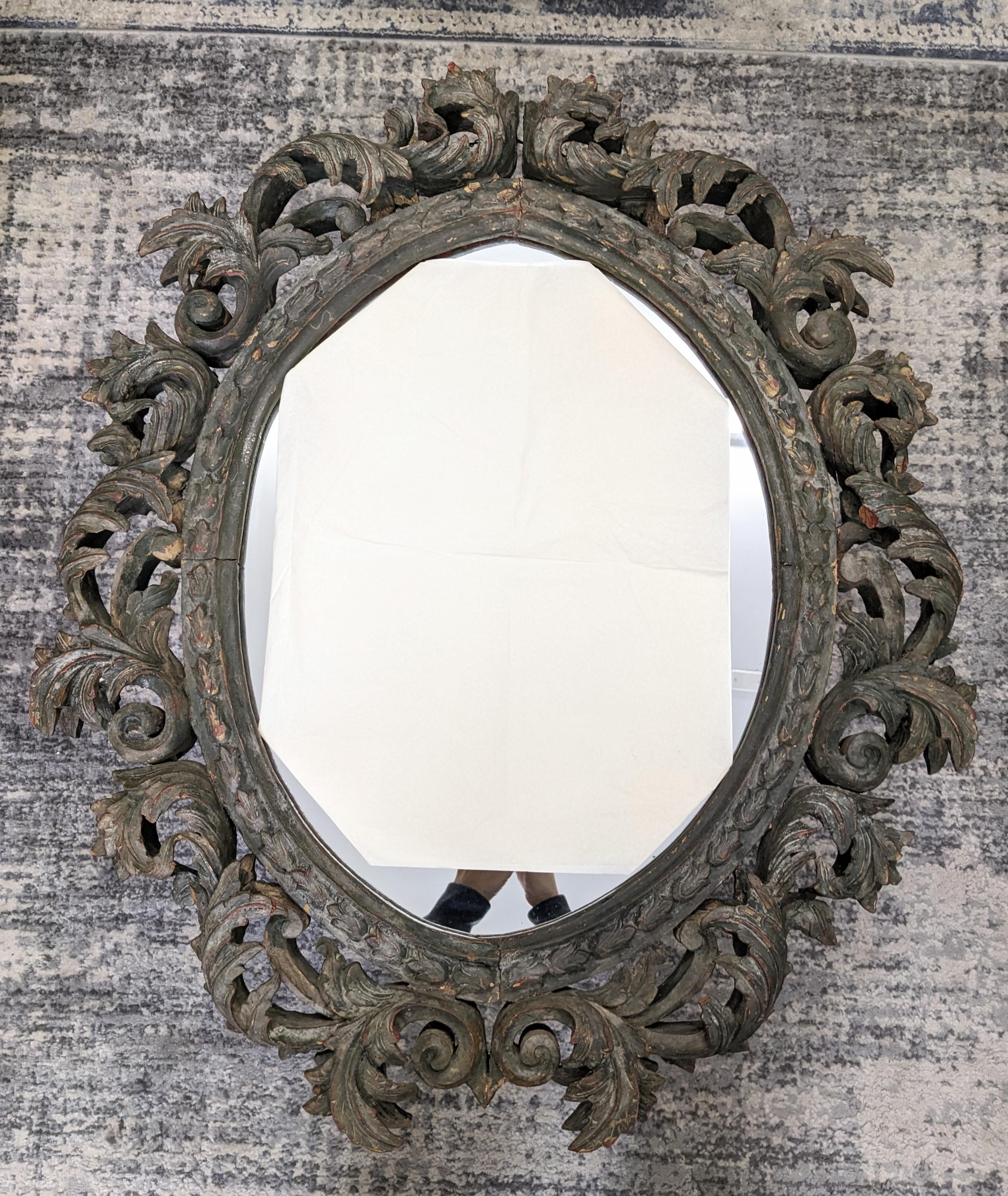 Impressive, heavily hand carved and 3D, dimensional 19th century carved Baroque mirror lightly stained in folk art evergreen tone.
Navette shaped mirror was possibly gilt in an earlier time although no traces remain except the reddish base coat.