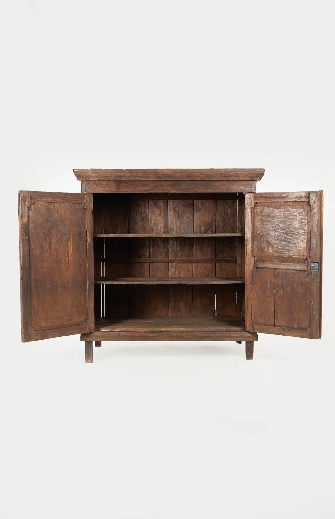 One-of-a-kind and rare colonial Indonesian antique cupboard featuring hand carved scalloped panelling and three internal horizontal shelves. 
The side and back are solid timber boards ensuring a long life and excellent quality craftsmanship.
A very