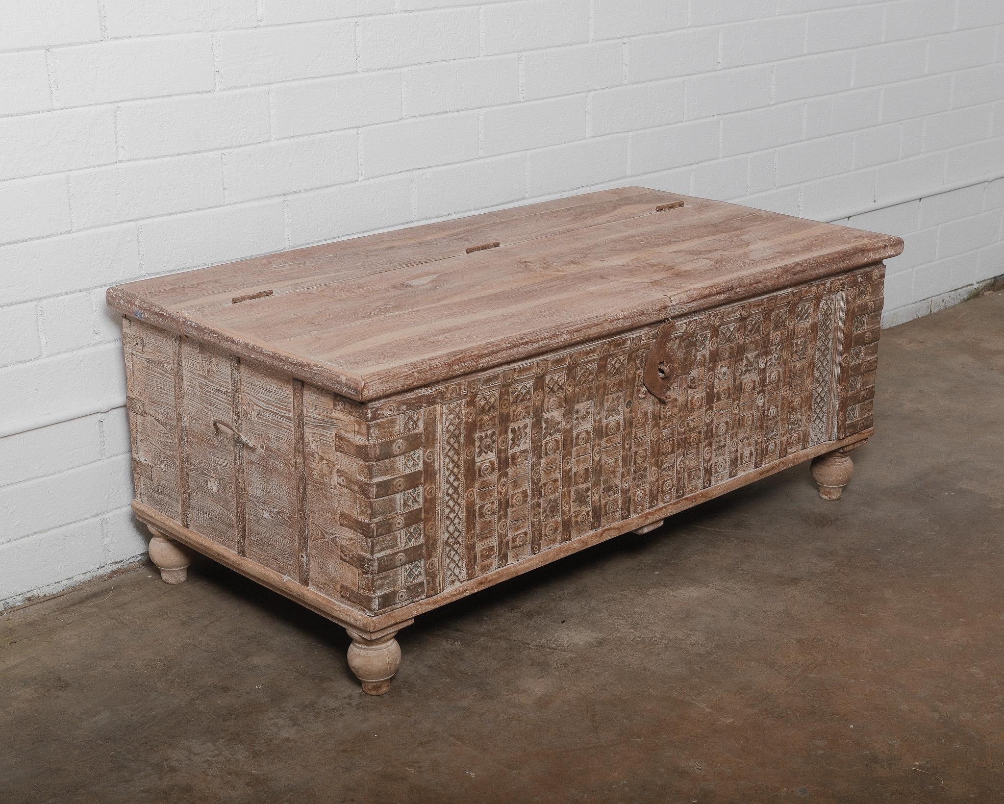 This 19th-century Indian hope chest is a masterfully crafted piece that embodies traditional artistry and timeless elegance. Hand-carved from solid wood, this antique trunk features intricate geometric and floral patterns on the front panel, a
