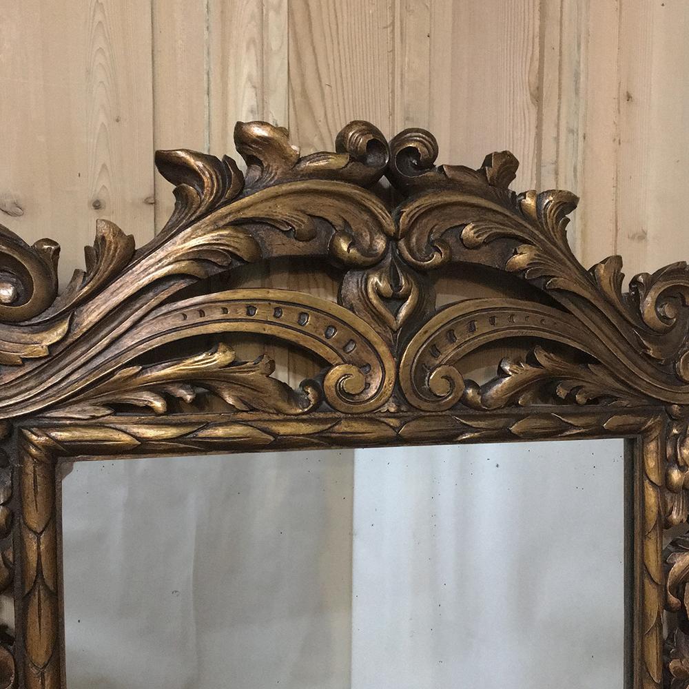 This impressive 19th century hand-carved Italian giltwood Baroque mirror was sculpted by an obviously talented Italian artist, features elaborate foliate and shell carvings surrounding the entire mirror, with a subdued gilded finish that makes it an