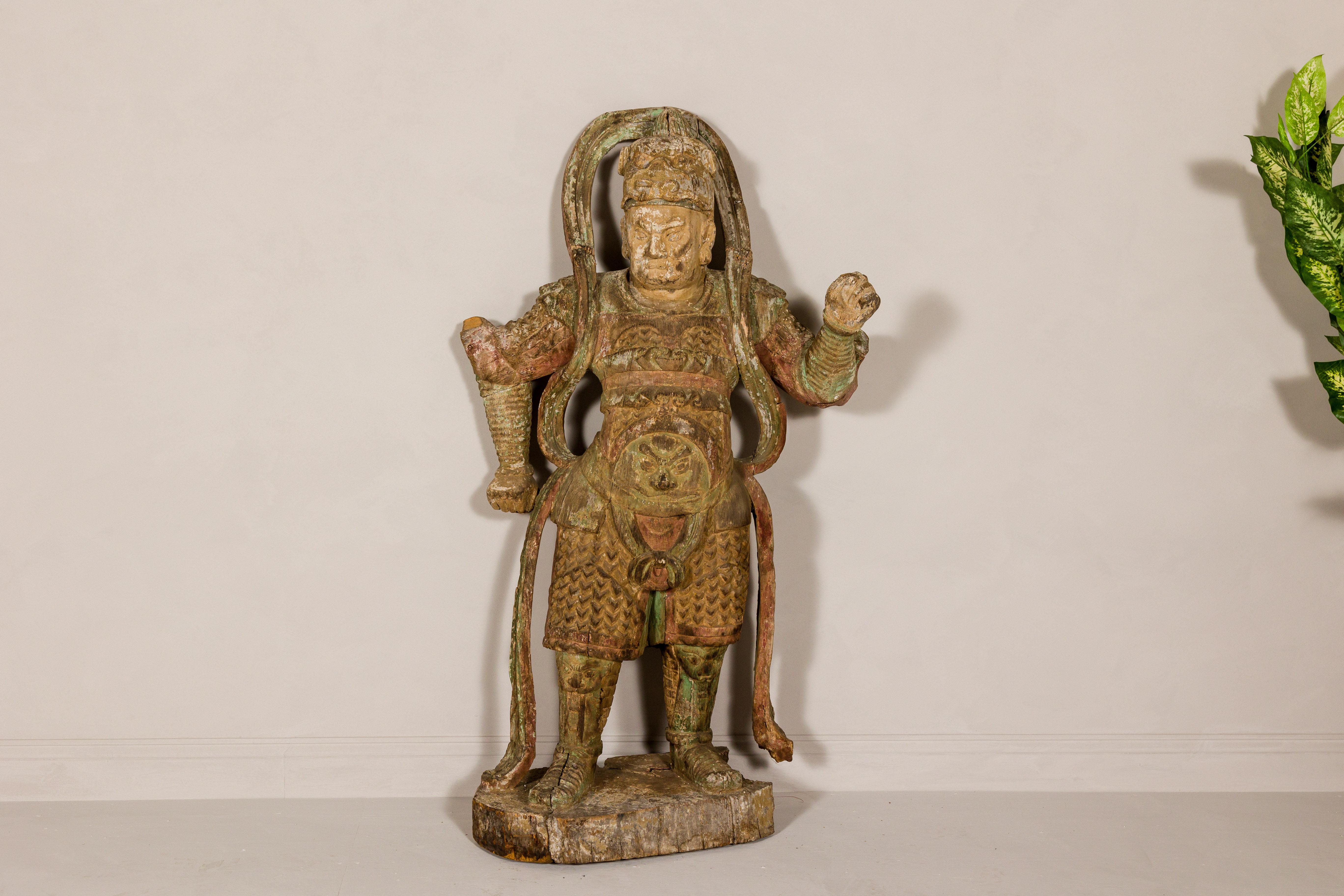 A hand-carved Japanese Samurai warrior statue from the 19th century with traces of a red and green polychromy.  Immersed in profound historical allure, this 19th-century Japanese Samurai warrior statue stands as a testament to the rich cultural