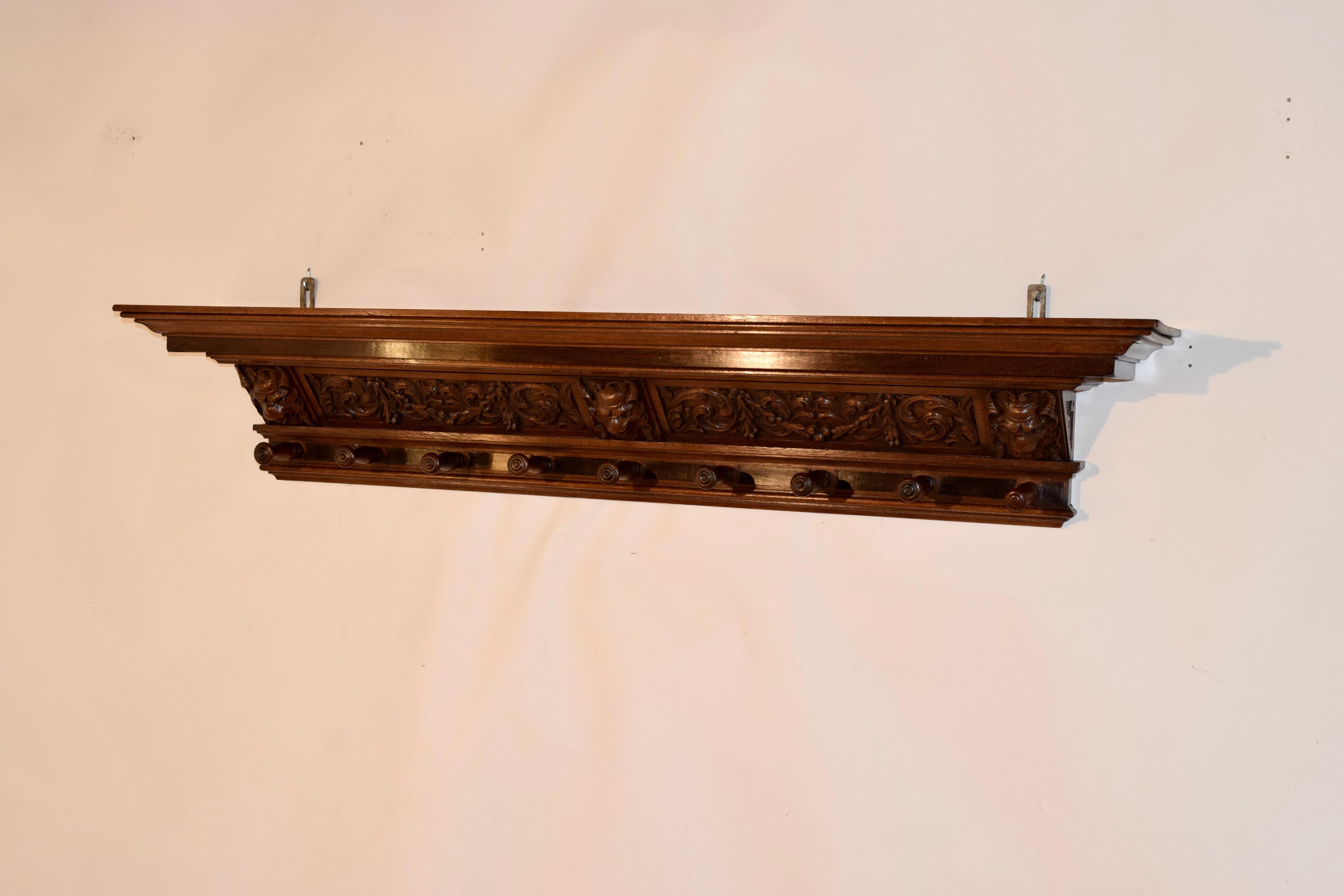 19th century hand carved decorated mantle shelf with wonderfully hand carved decoration. The top is nicely molded and is supported on a hand carved base with floral swags, acanthus leaves and figures over nine hand turned hangers. The photos do not